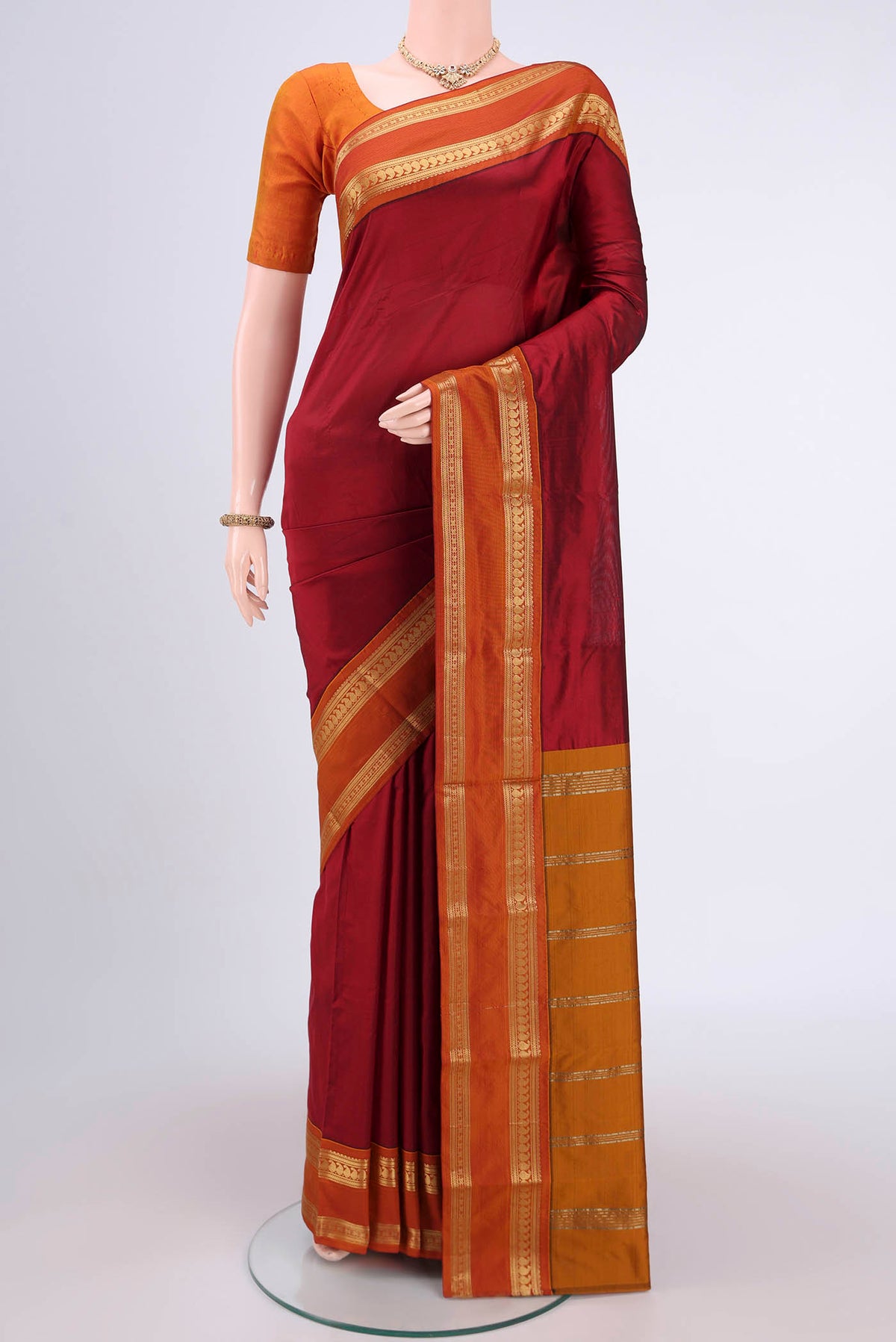Maroon Bangalore Silk Saree with Plain Body and Zari Border.  displayed on a mannequin