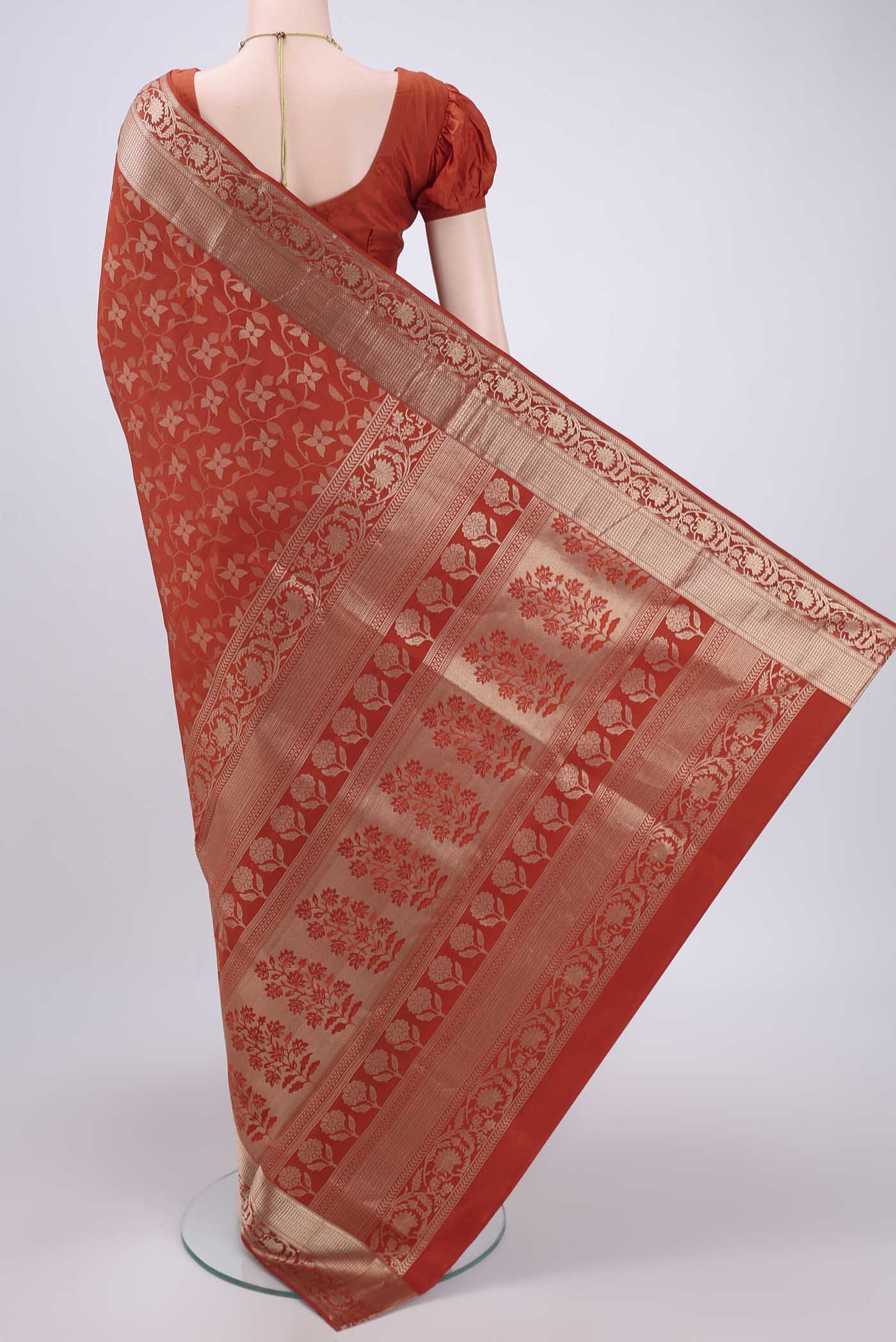 Flat view of Rust Soft Silk Saree with Zari Brocade on the body and Zari Border. 