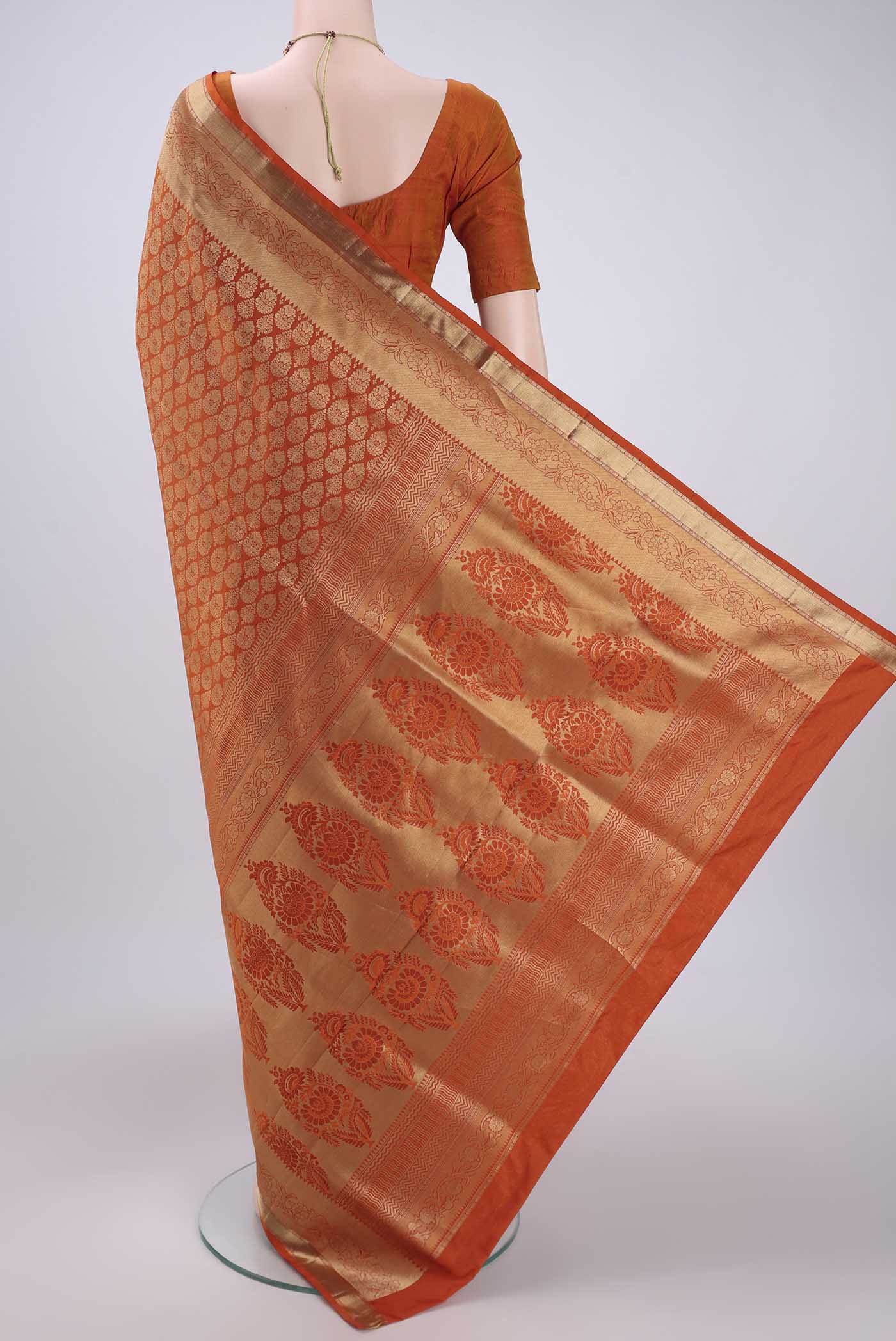 Flat view of Rust Soft Silk Saree with Zari Brocade on the body and Zari Border. 