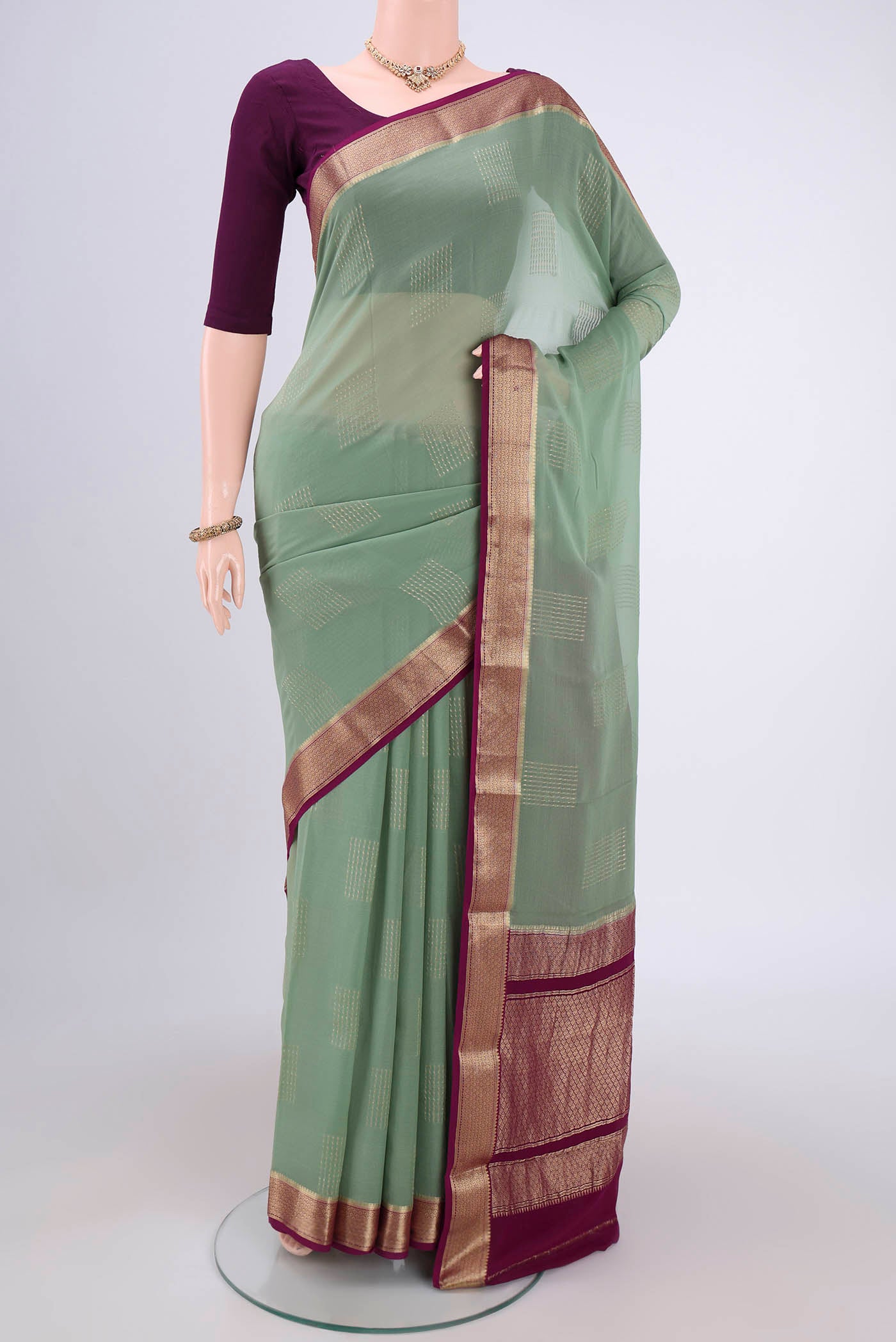 Pista Green Georgette Saree with Zari Butta on the body and Zari Border.  displayed on a mannequin