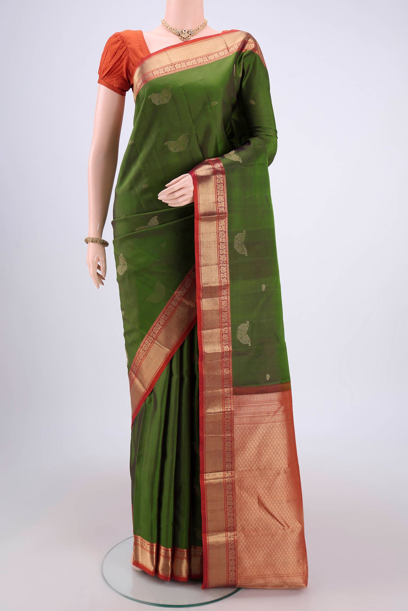 Green Kanchipuram Silk Saree with Zari Butta on the body and Zari Border.  displayed on a mannequin