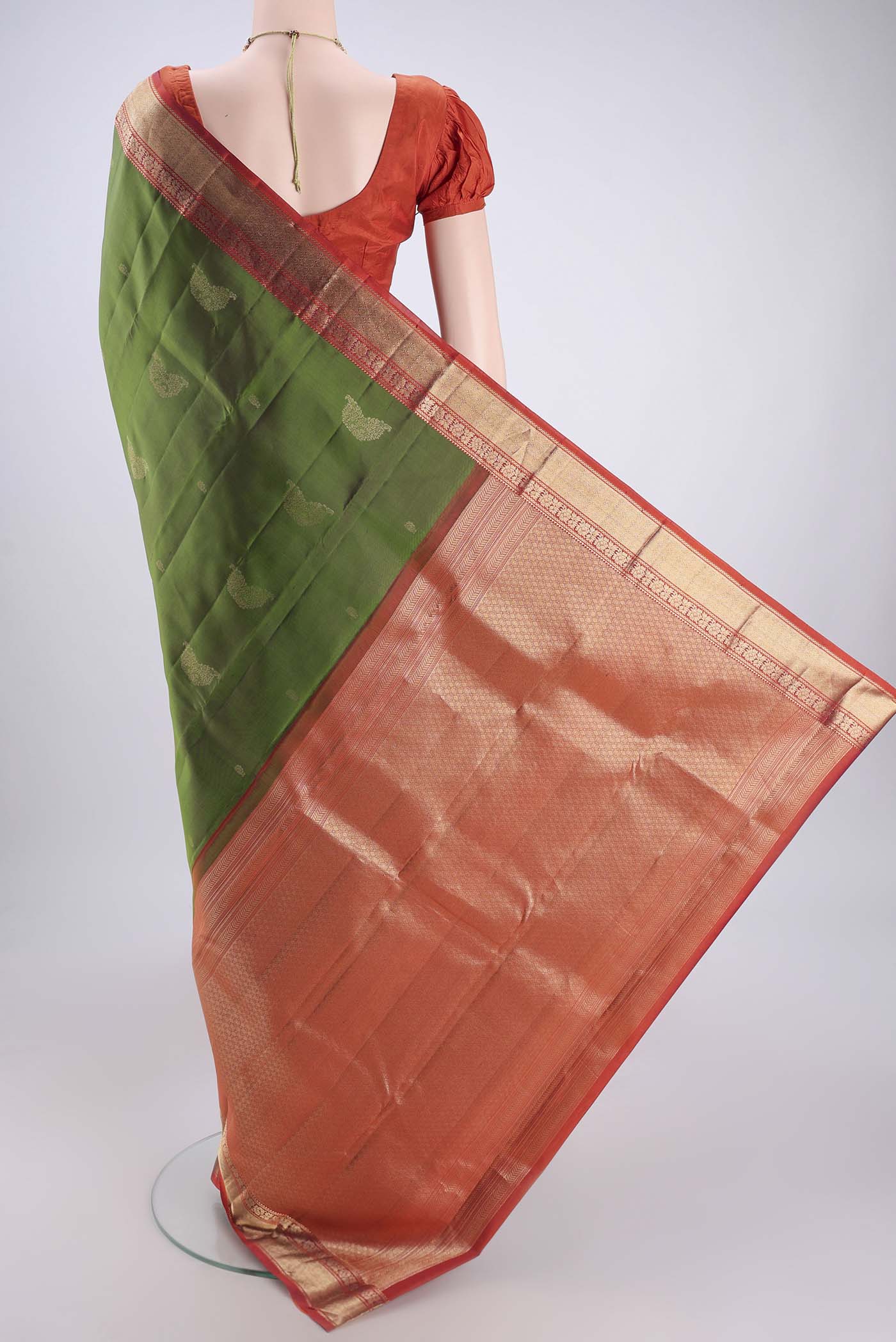 Flat view of Green Kanchipuram Silk Saree with Zari Butta on the body and Zari Border. 