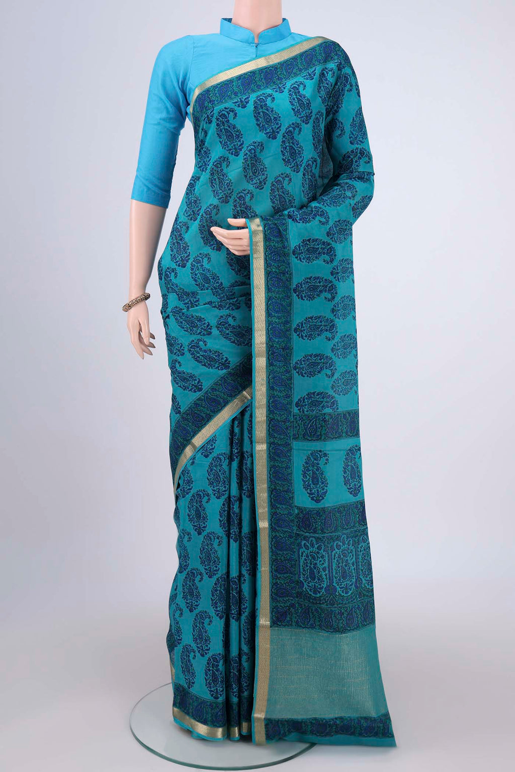 Teal Mysore Crepe Saree with Floral Print on the body and Zari Border.  displayed on a mannequin