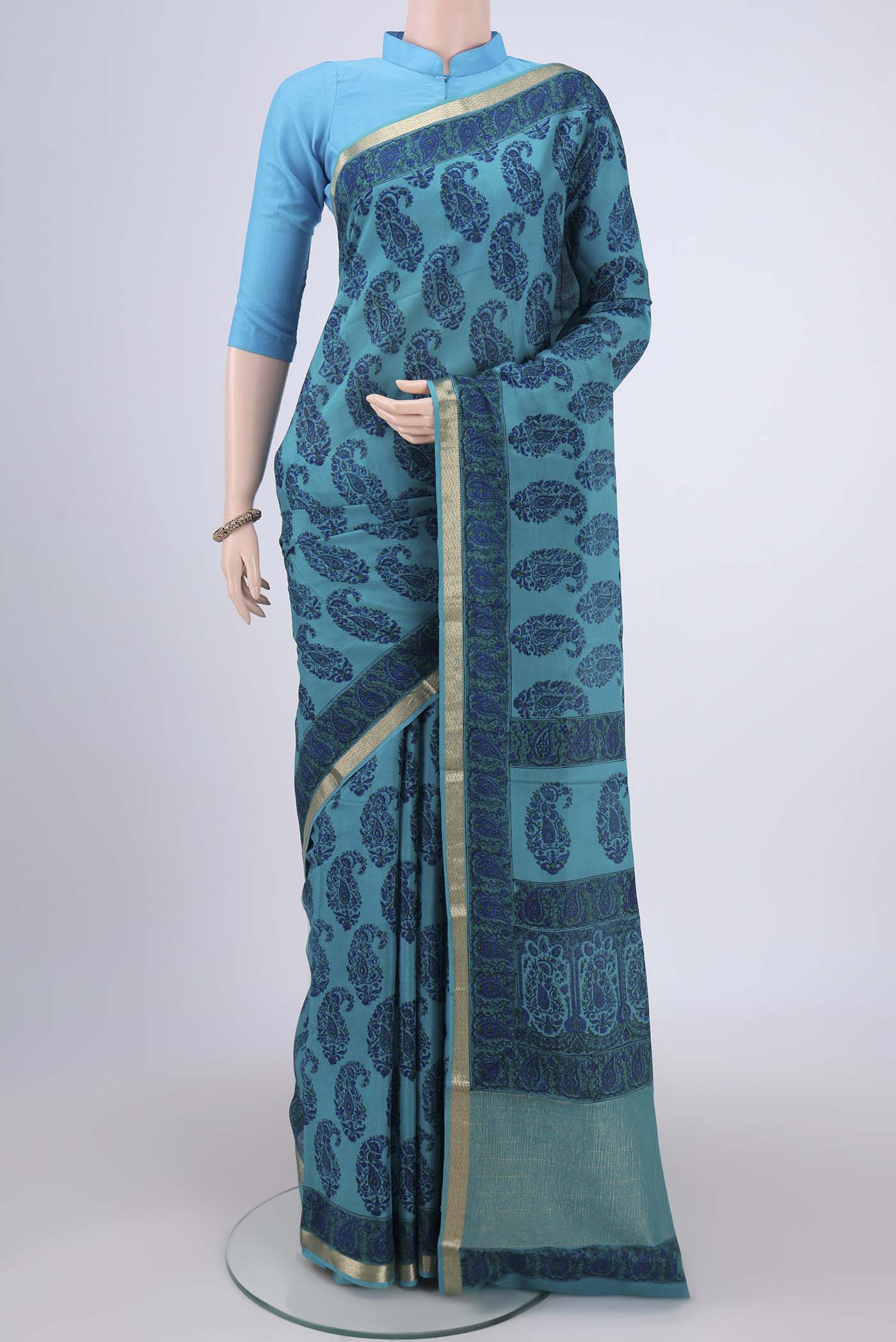 Teal Mysore Crepe Saree with Floral Print on the body and Zari Border.  displayed on a mannequin