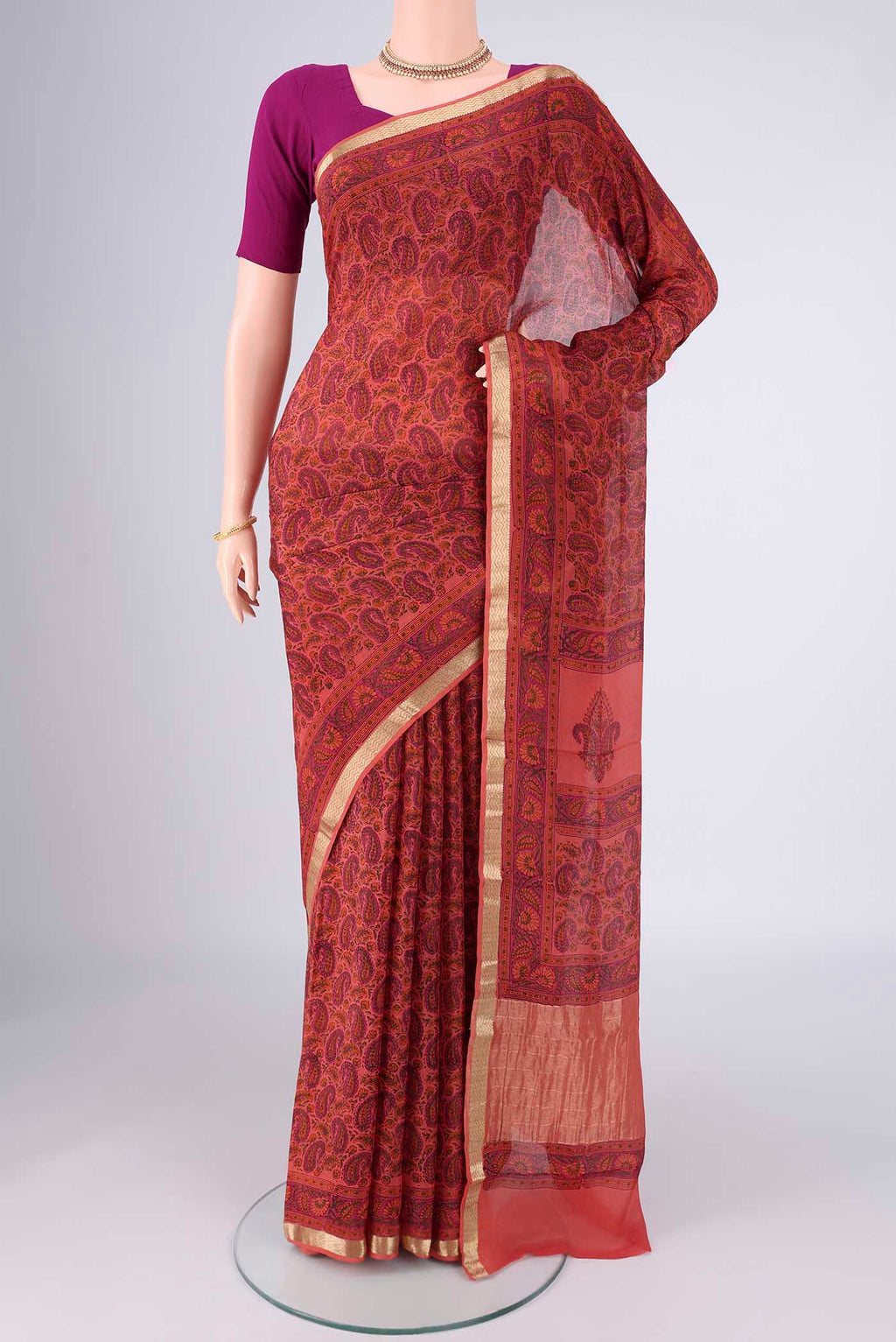 Coral Mysore Crepe Saree with Printed design on the body and Zari Border.  displayed on a mannequin