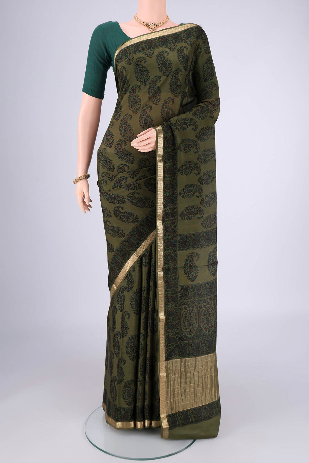 Olive Green Mysore Crepe Saree with Printed design on the body and Zari Border.  displayed on a mannequin