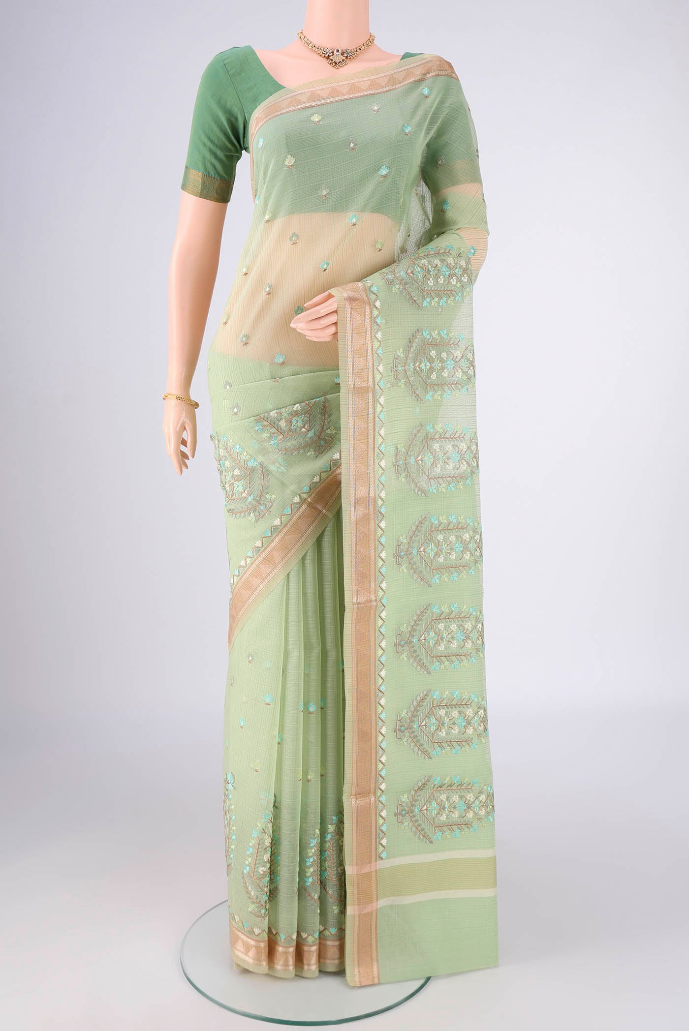 Light Green Blended Kota Cotton Saree with Embroidery on the body and Zari Border.  displayed on a mannequin