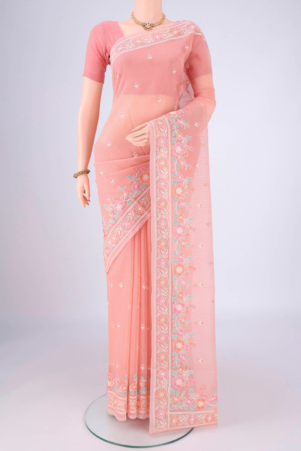 Peach Blended Kota Cotton Saree with Embroidery on the body and Thread Border.  displayed on a mannequin