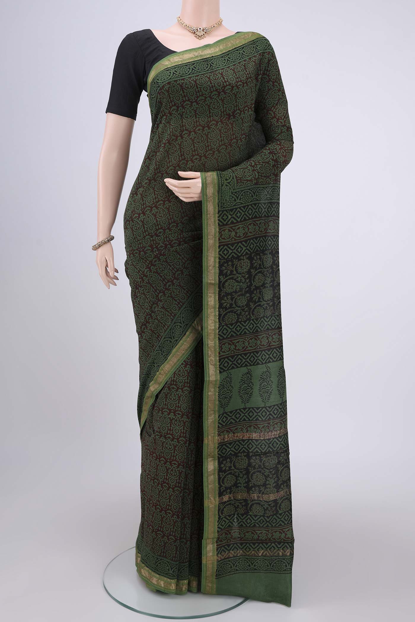 Green Maheshwari Silk Cotton Saree with Batik Print on the body and Zari Border.  displayed on a mannequin