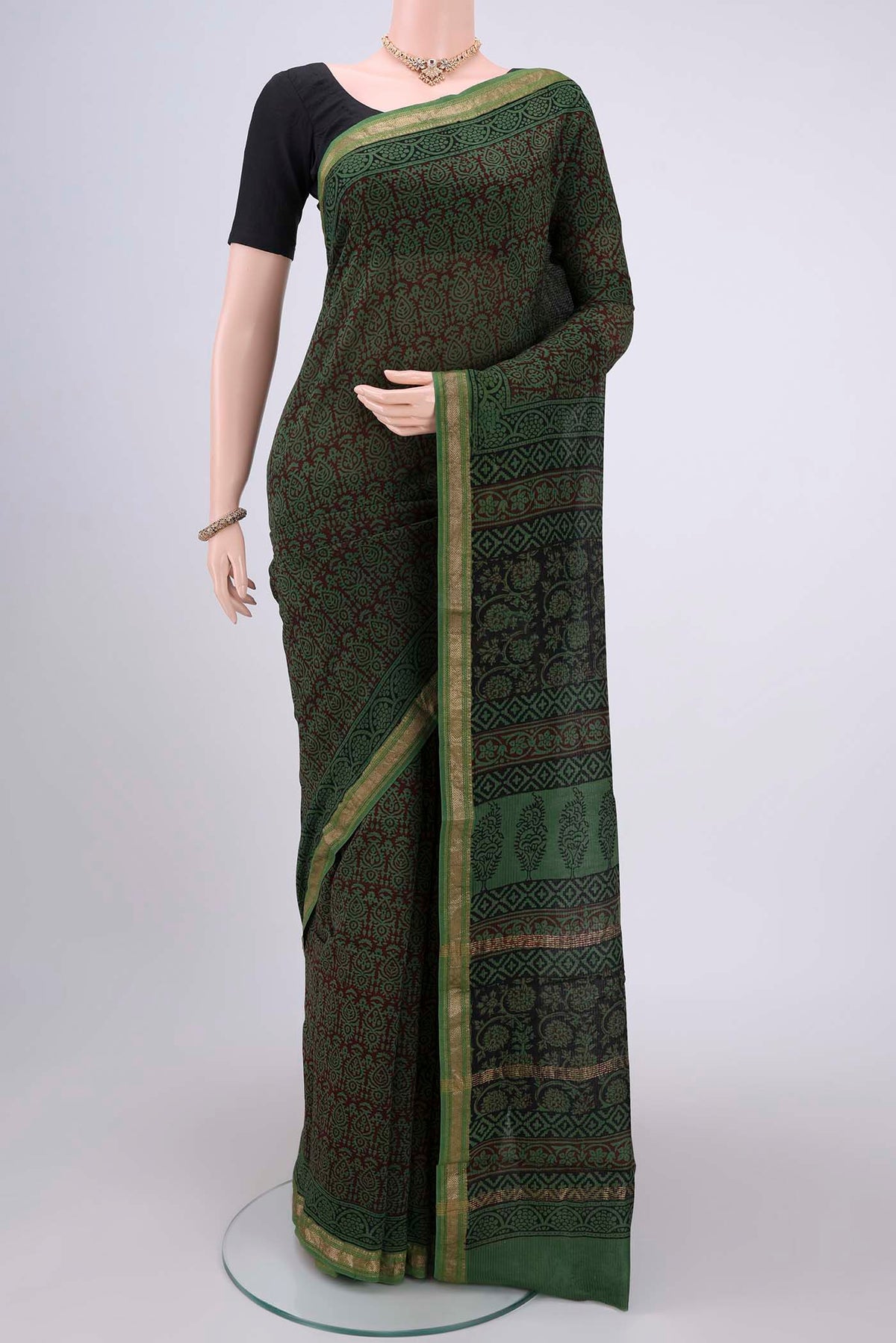 Green Maheshwari Silk Cotton Saree with Batik Print on the body and Zari Border.  displayed on a mannequin