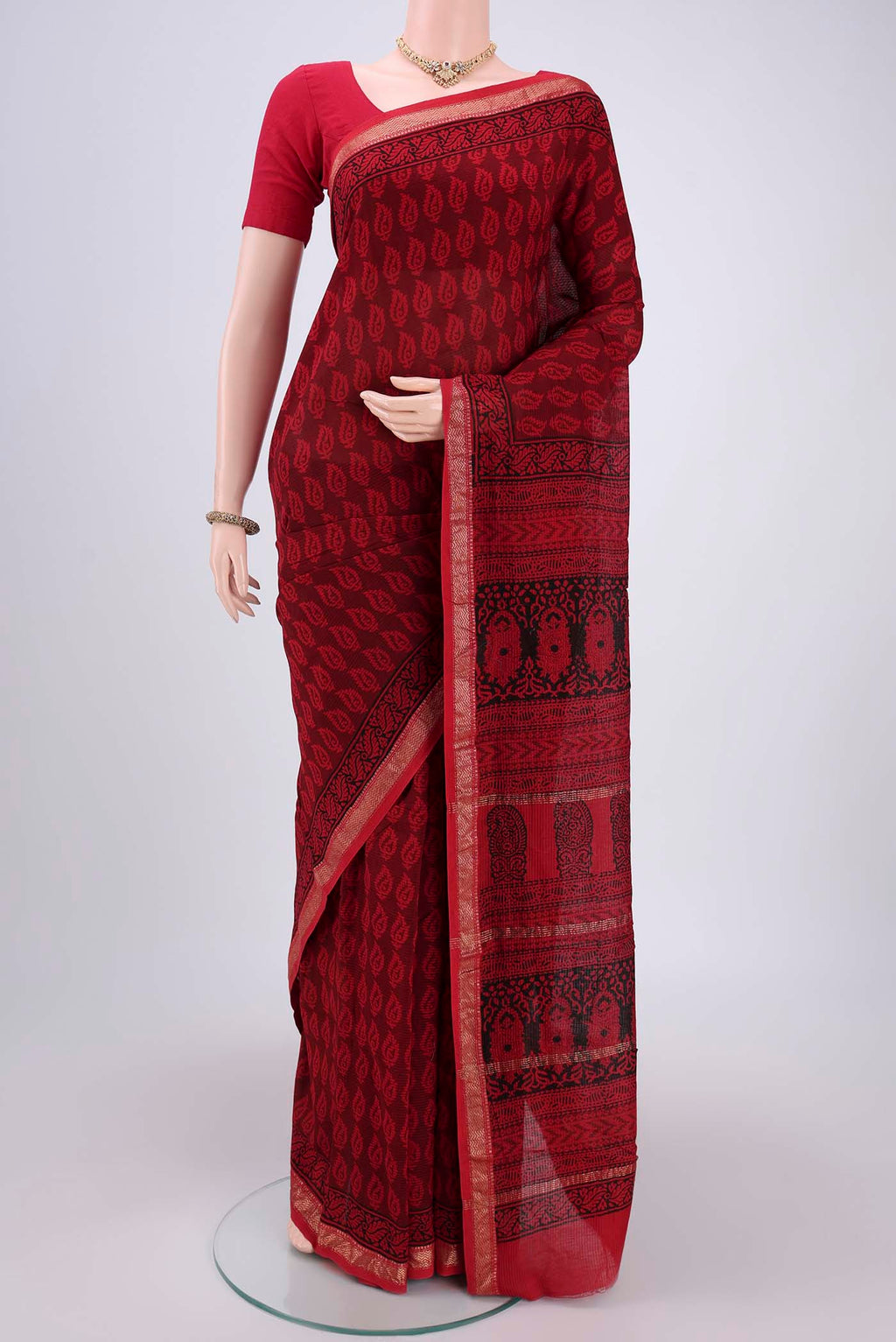 Red Maheshwari Silk Cotton Saree with Batik Print on the body and Zari Border.  displayed on a mannequin