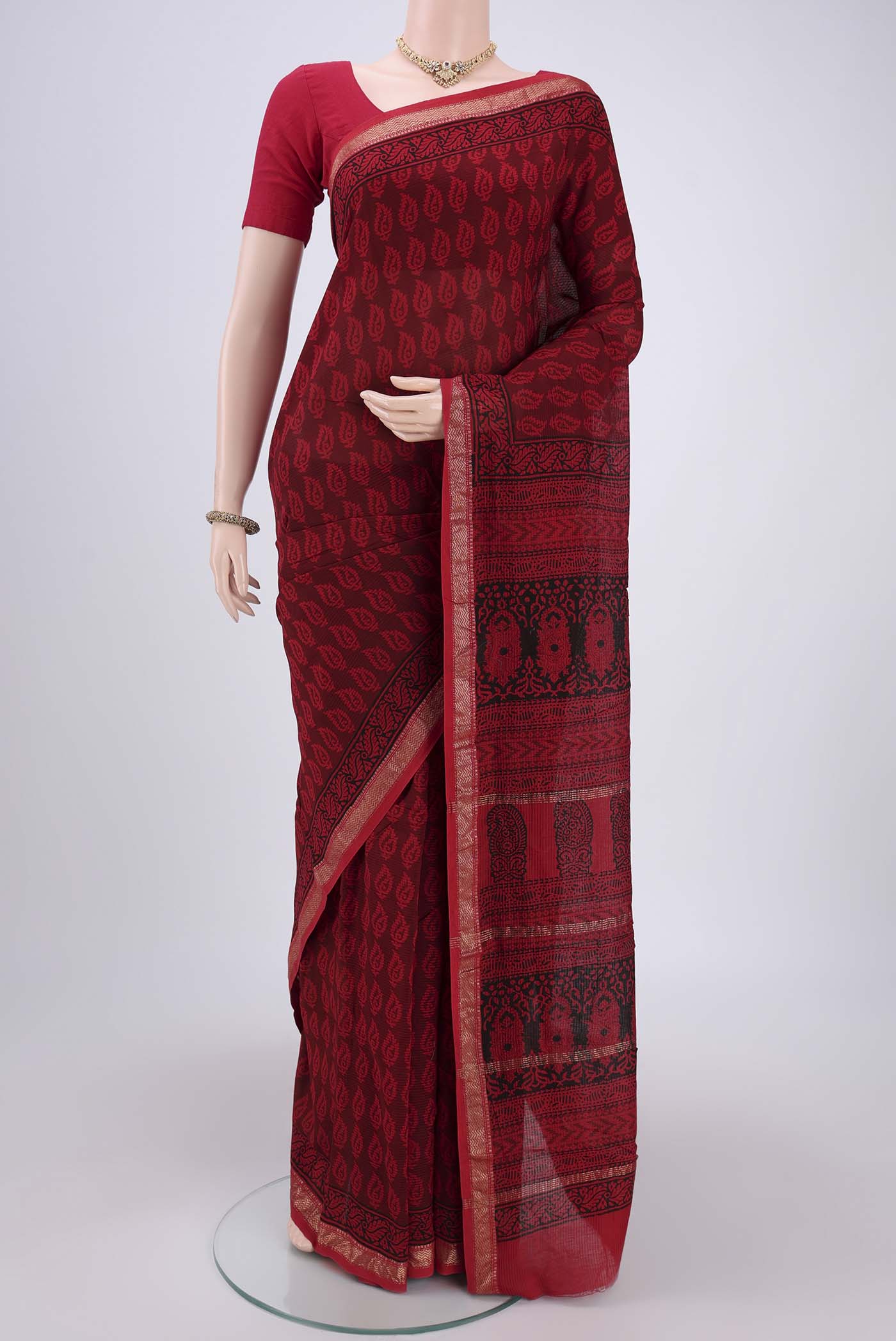 Red Maheshwari Silk Cotton Saree with Batik Print on the body and Zari Border.  displayed on a mannequin