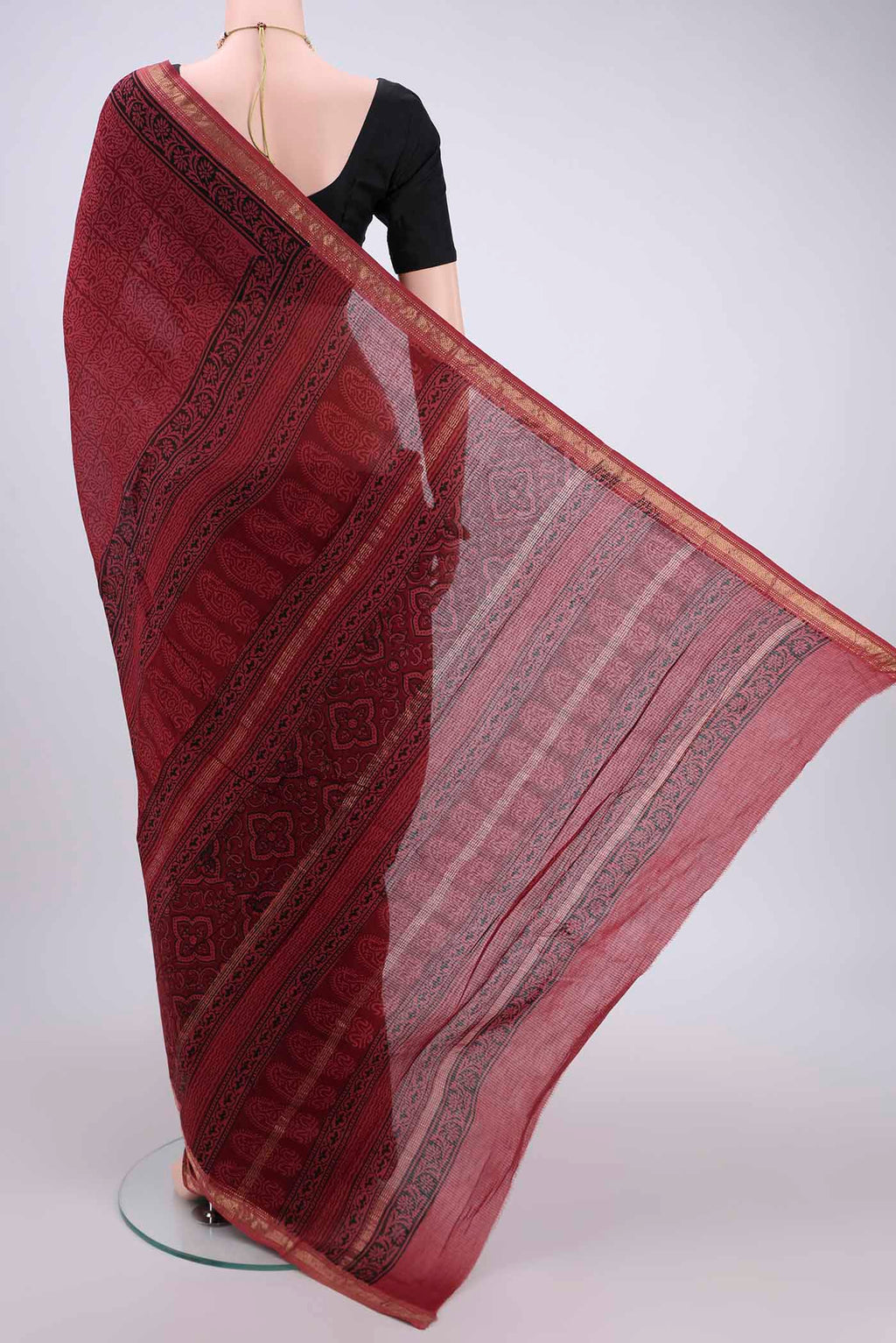 Flat view of Maroon Maheshwari Silk Cotton Saree with Batik Print on the body and Zari Border. 