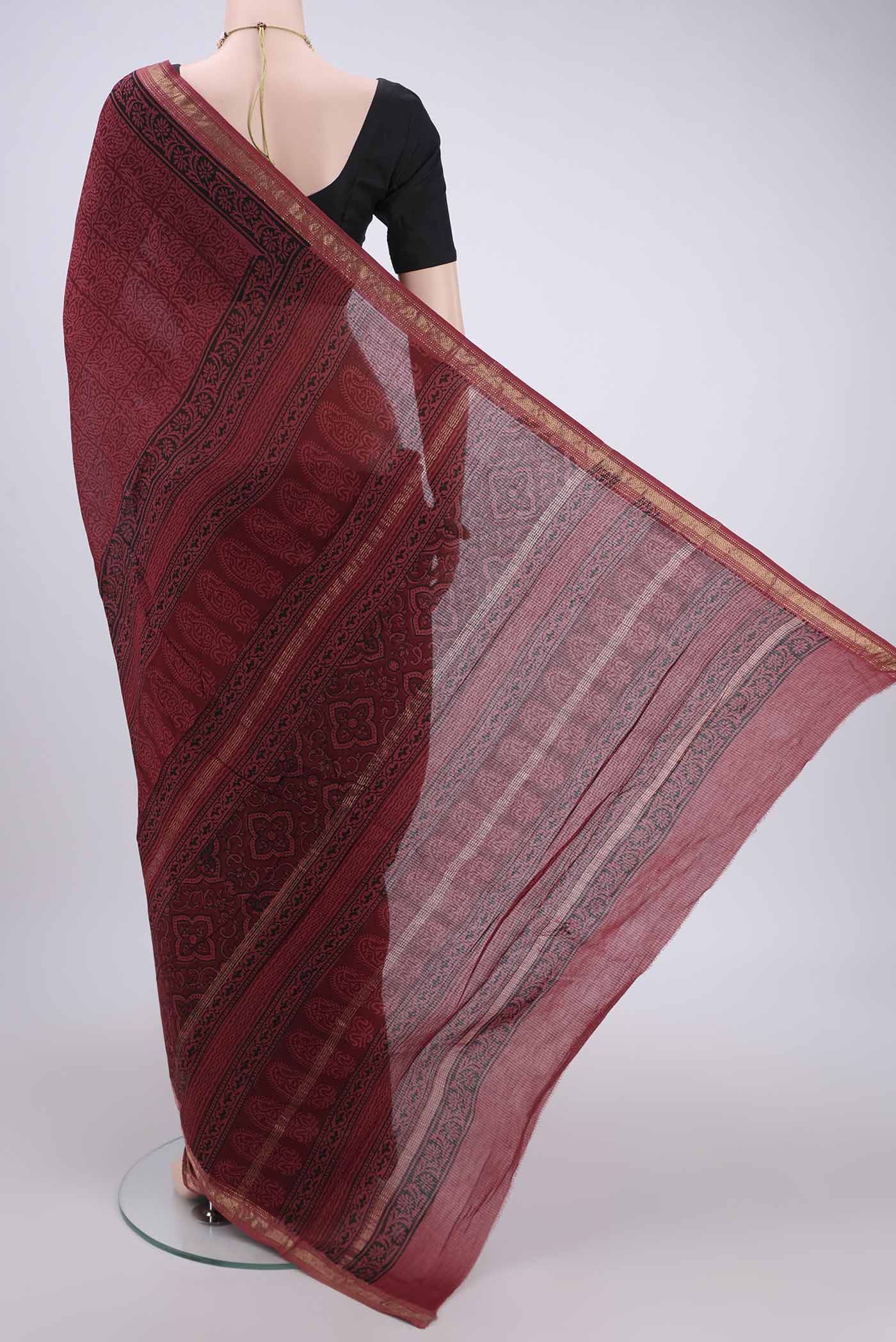 Flat view of Maroon Maheshwari Silk Cotton Saree with Batik Print on the body and Zari Border. 