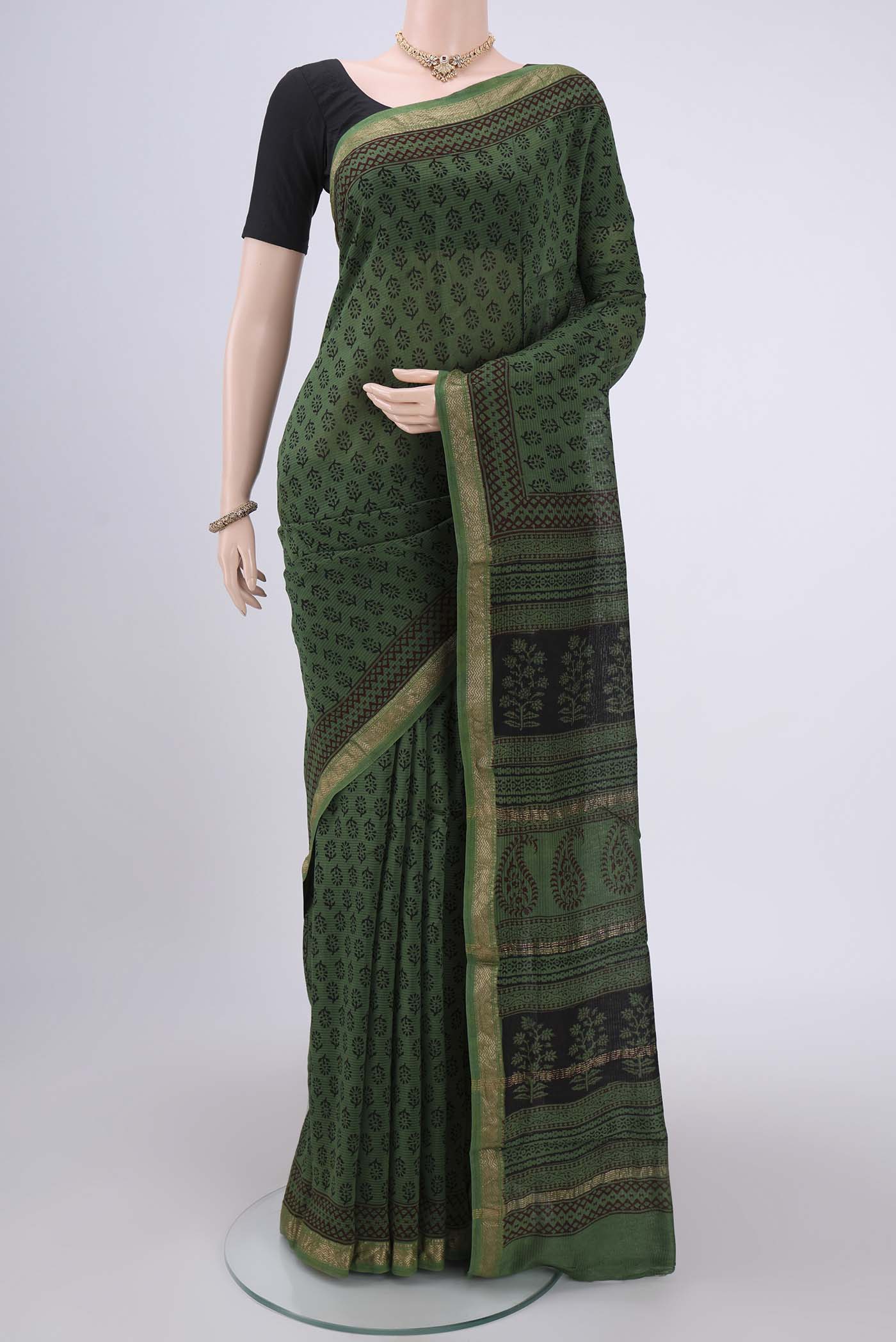 Green Maheshwari Silk Cotton Saree with Batik Print on the body and Zari Border.  displayed on a mannequin