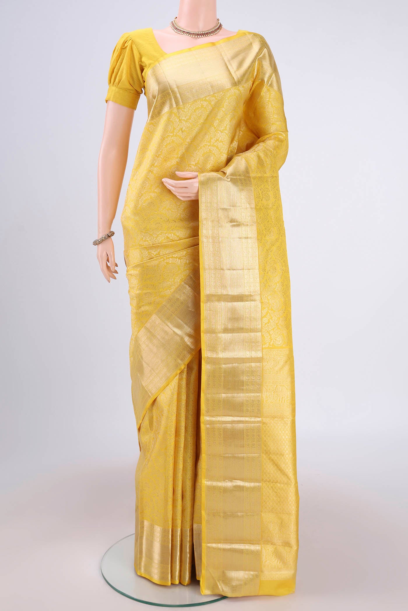 Lemon Yellow Kanchipuram Silk Saree with Zari Brocade on the body and Zari Border.  displayed on a mannequin