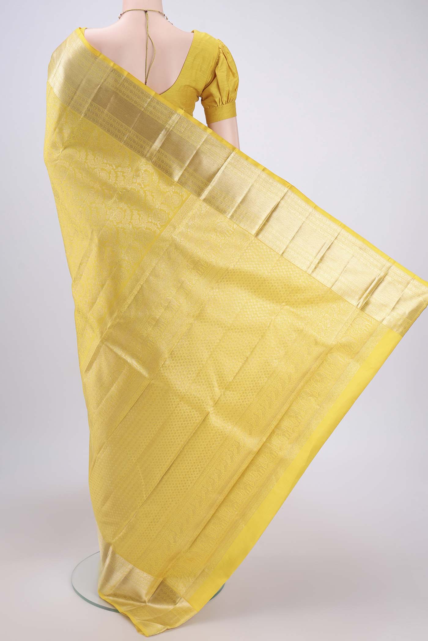 Flat view of Lemon Yellow Kanchipuram Silk Saree with Zari Brocade on the body and Zari Border. 