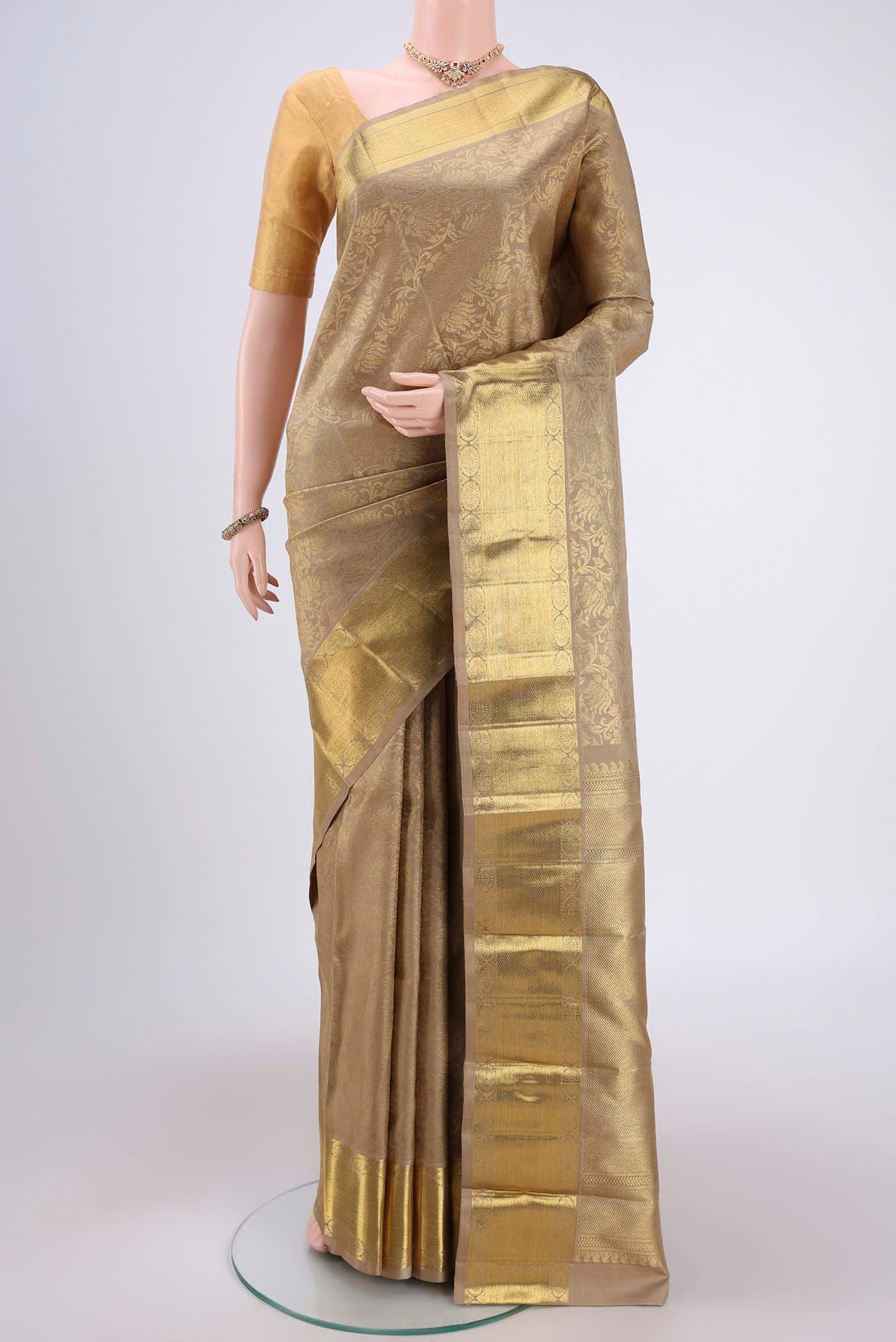 Pure Silk Pure Zari Beige Kanjivaram Saree with Zari Butta on the body and Zari Border.  displayed on a mannequin