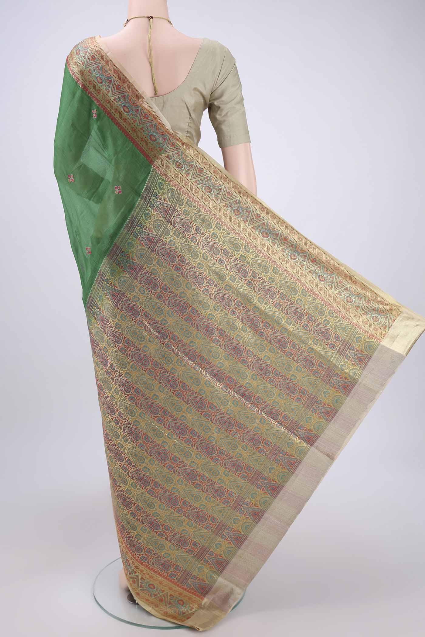Flat view of Green Banarasi Tussar Silk Saree with Embroidery on the body and Zari And Thread Border. 