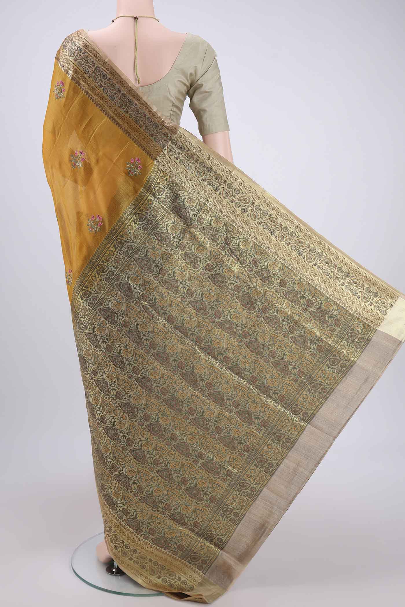 Flat view of Yellow Banarasi Tussar Silk Saree with Embroidery on the body and Zari And Thread Border. 