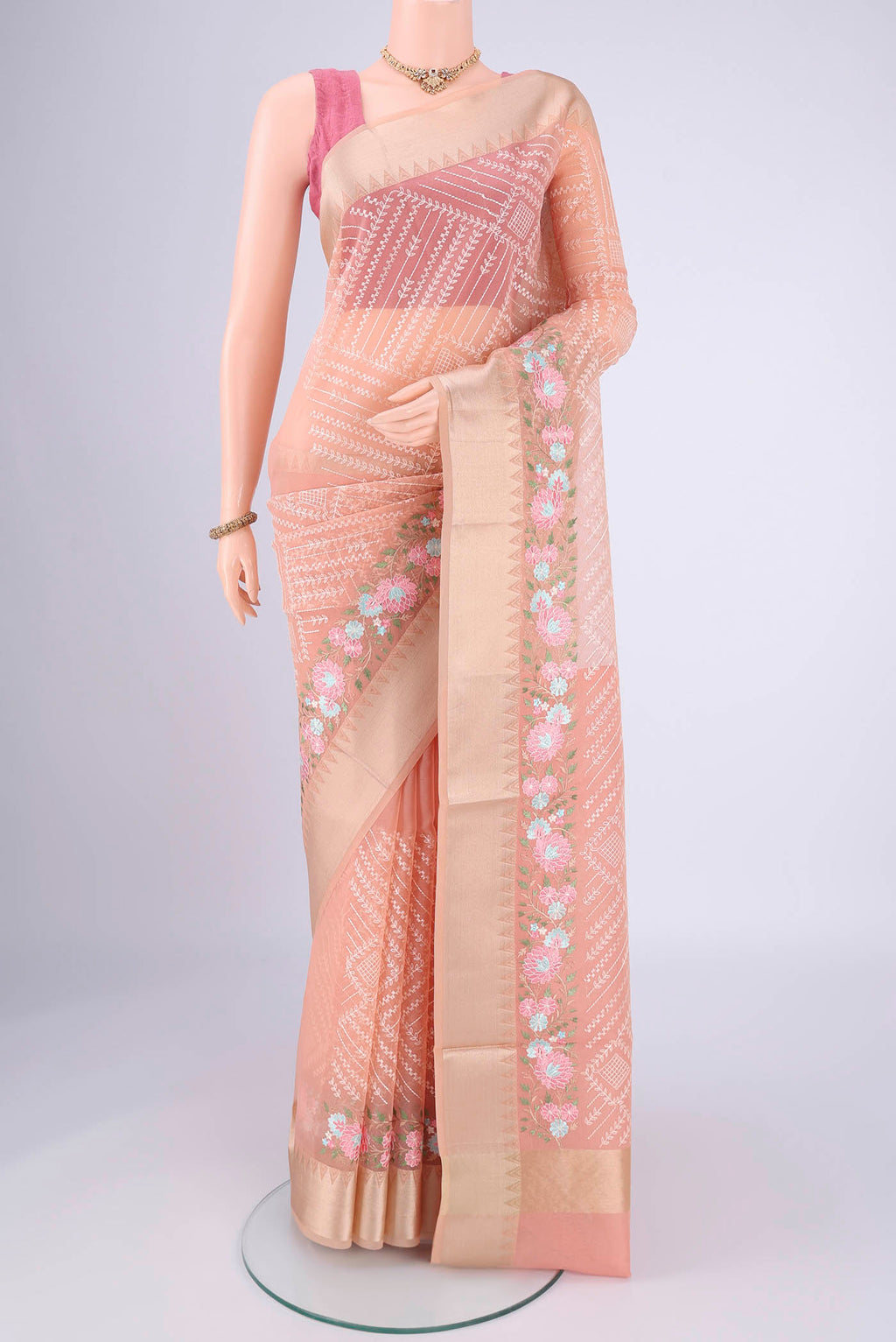 Peach Blended Kota Cotton Saree with Embroidery on the body and Zari Border.  displayed on a mannequin