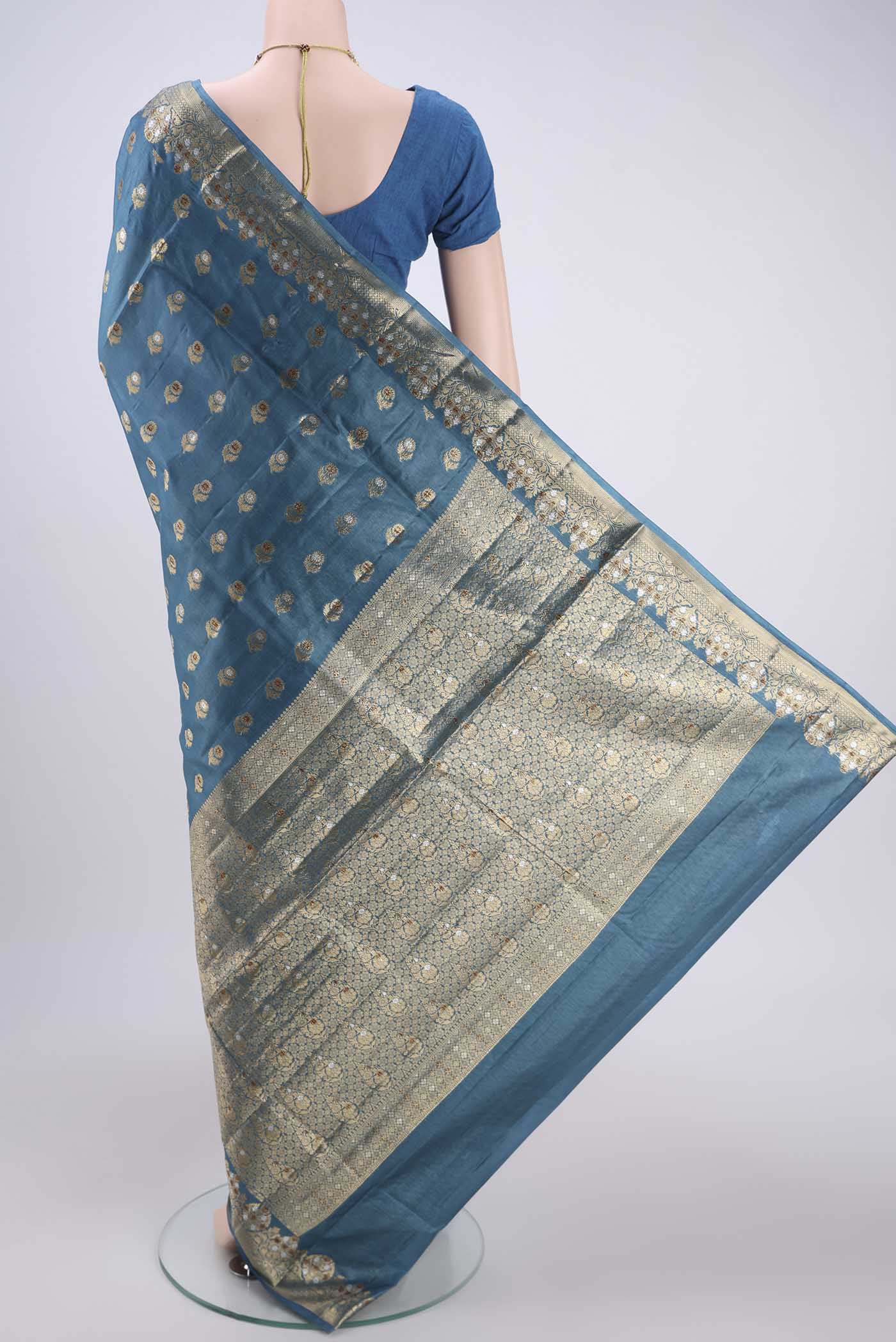 Flat view of Electric Blue Banarasi Tussar Silk Saree with Zari And Thread Butta on the body and Zari And Thread Border. 