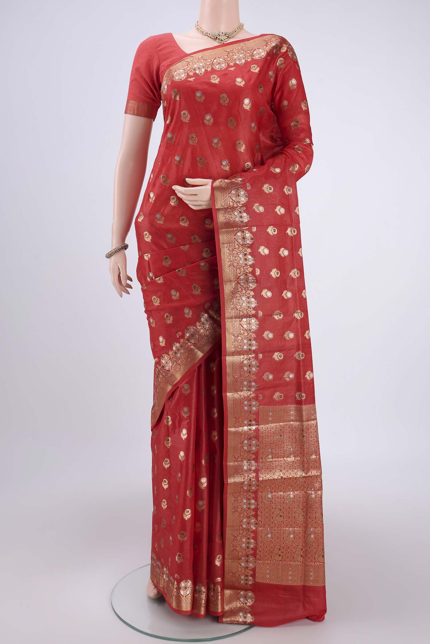 Orange Banarasi Tussar Silk Saree with Zari And Thread Butta on the body and Zari And Thread Border.  displayed on a mannequin