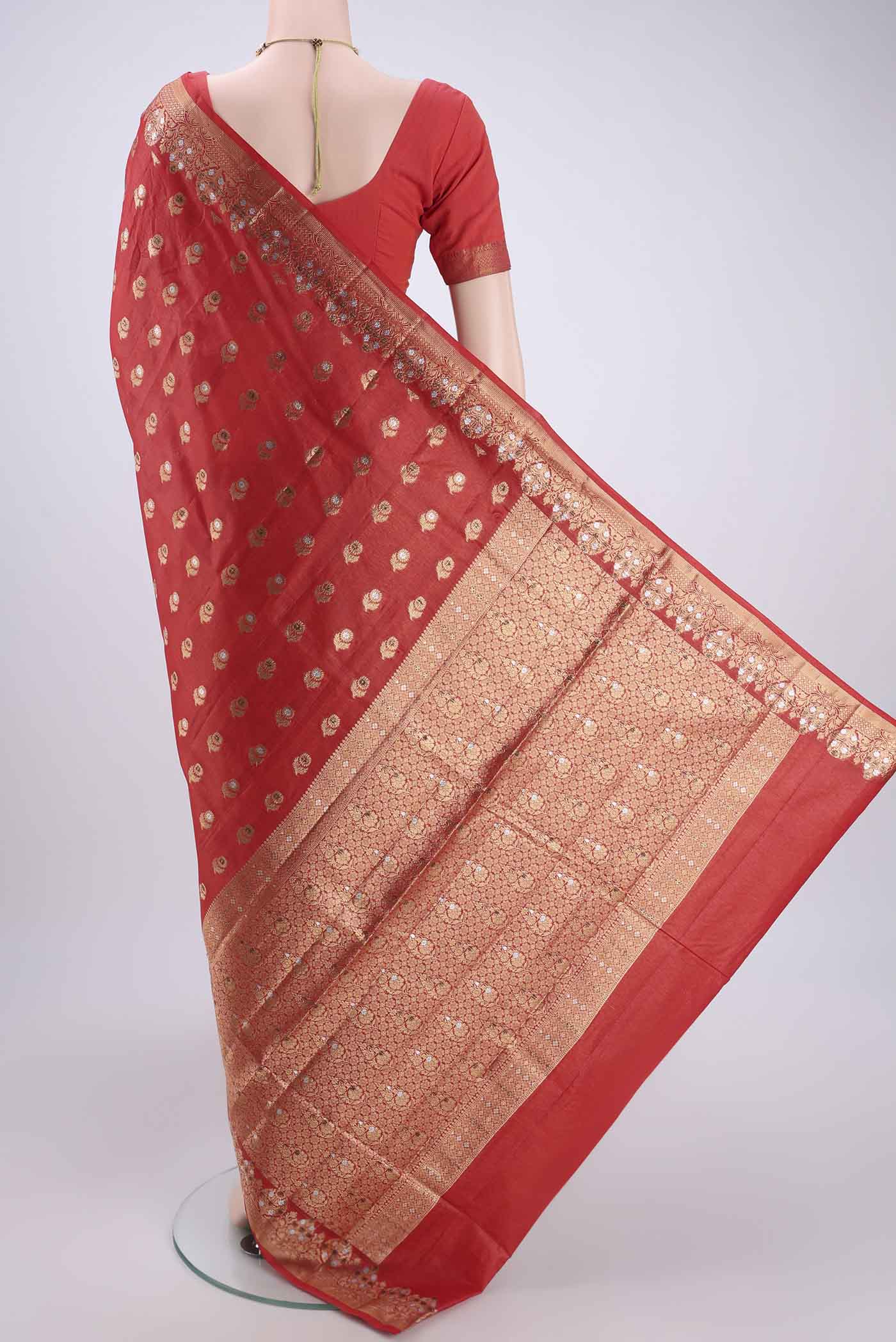 Flat view of Orange Banarasi Tussar Silk Saree with Zari And Thread Butta on the body and Zari And Thread Border. 