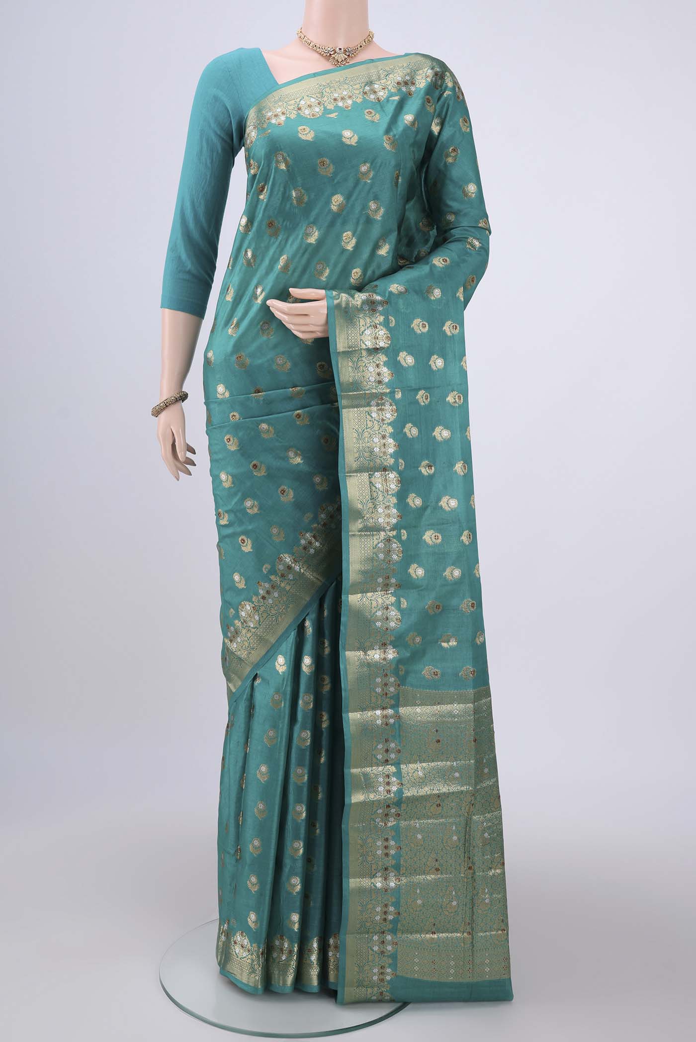 Turquoise Banarasi Tussar Silk Saree with Zari And Thread Butta on the body and Zari And Thread Border.  displayed on a mannequin