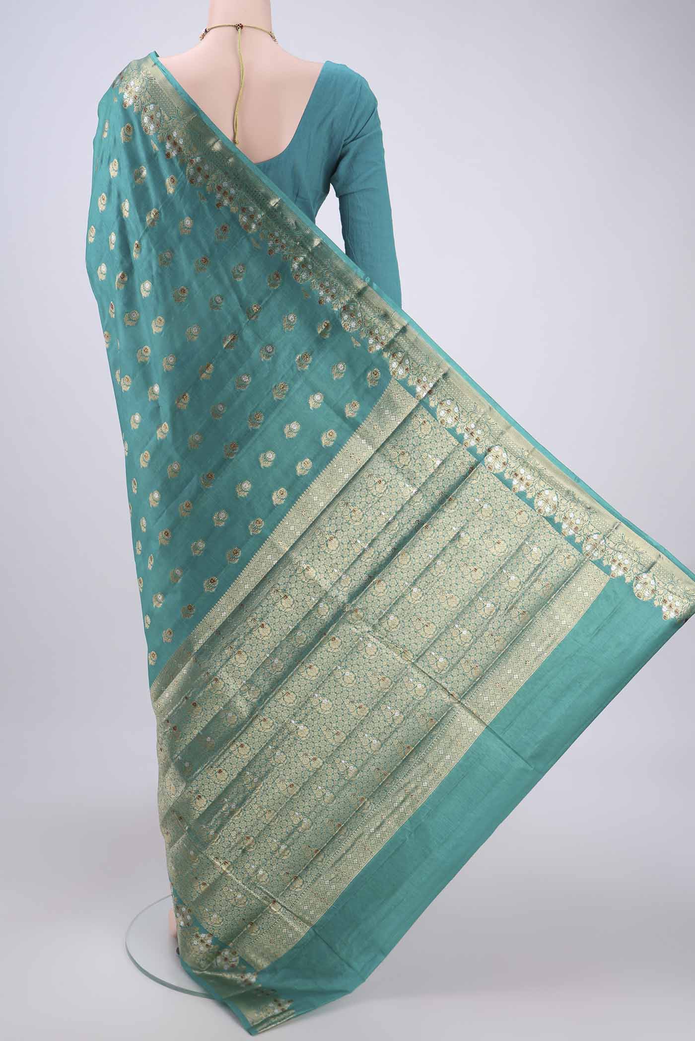 Flat view of Turquoise Banarasi Tussar Silk Saree with Zari And Thread Butta on the body and Zari And Thread Border. 