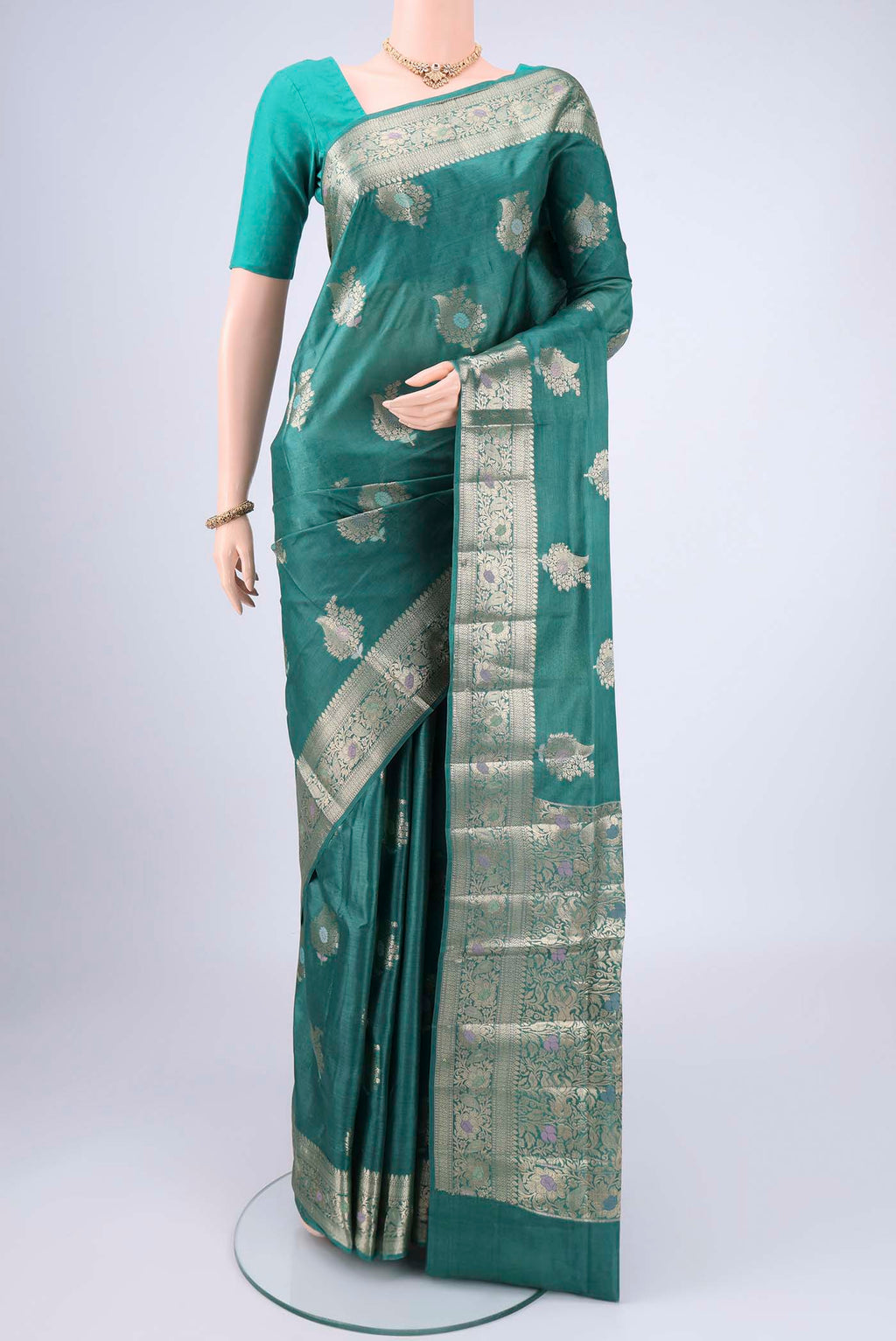 Green Banarasi Tussar Silk Saree with Zari And Thread Butta on the body and Zari And Thread Border.  displayed on a mannequin