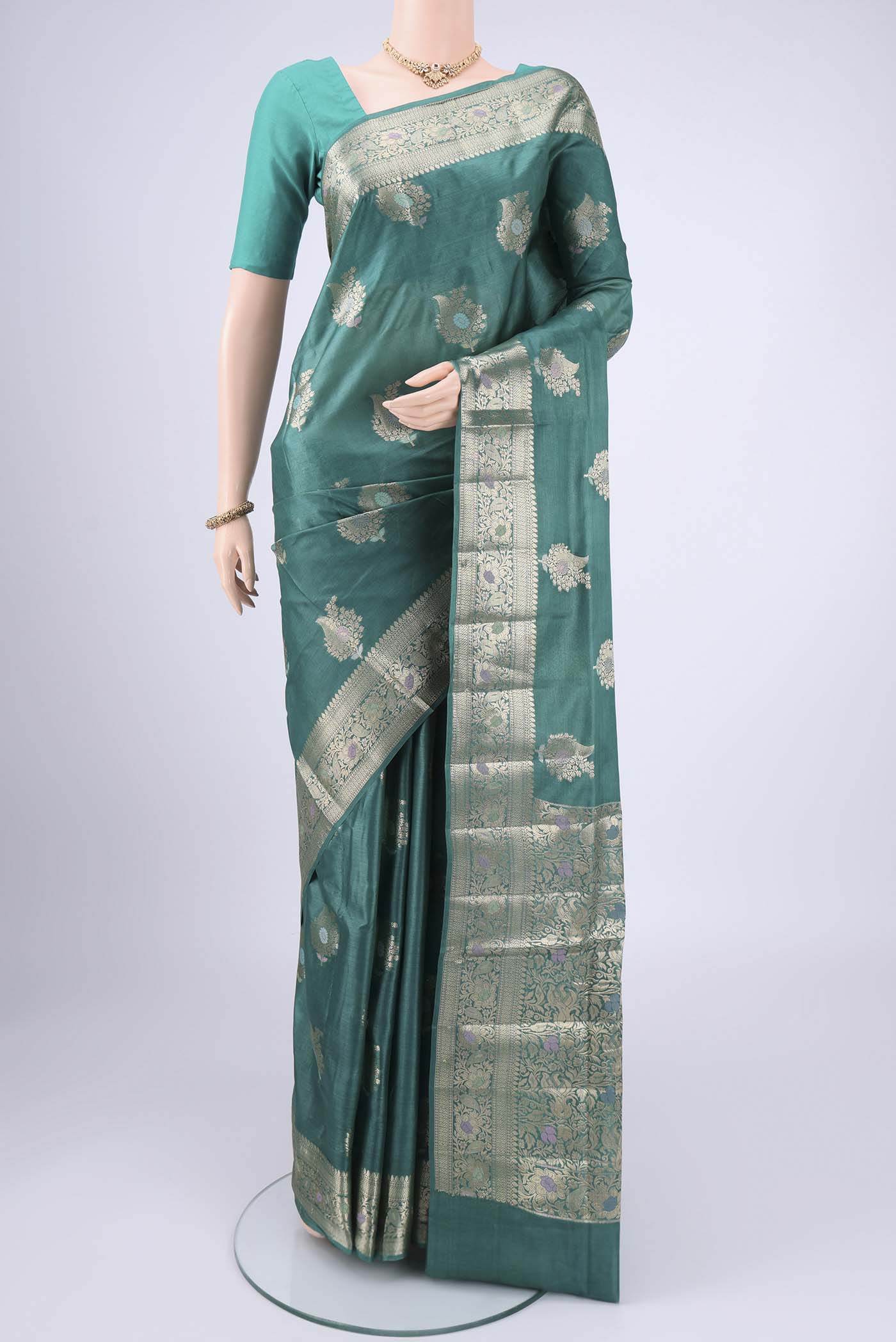 Green Banarasi Tussar Silk Saree with Zari And Thread Butta on the body and Zari And Thread Border.  displayed on a mannequin