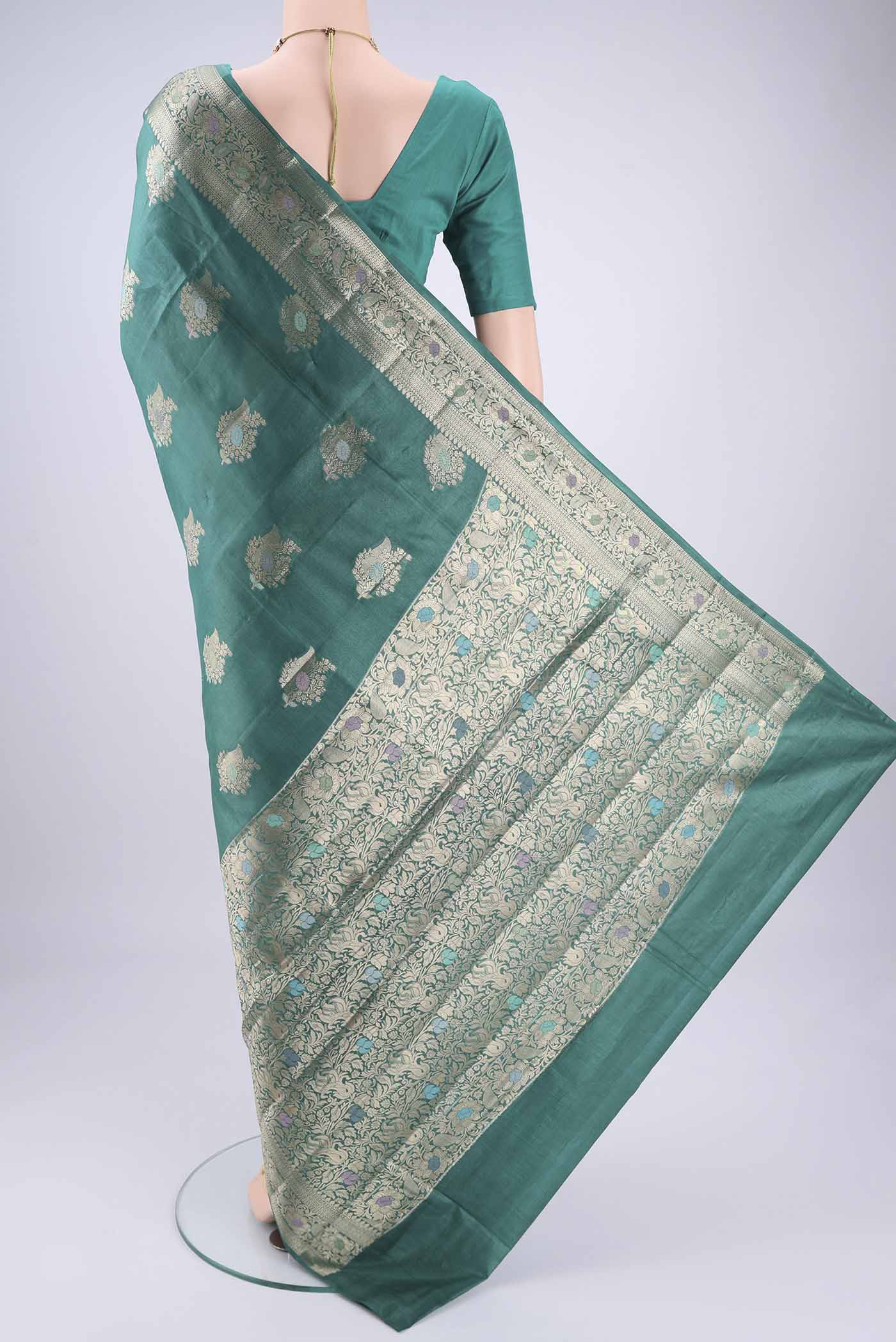 Flat view of Green Banarasi Tussar Silk Saree with Zari And Thread Butta on the body and Zari And Thread Border. 