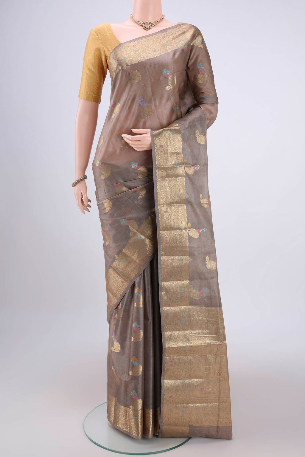Dark Beige Banarasi Tussar Silk Saree with Zari And Thread Butta on the body and Zari And Thread Border.  displayed on a mannequin