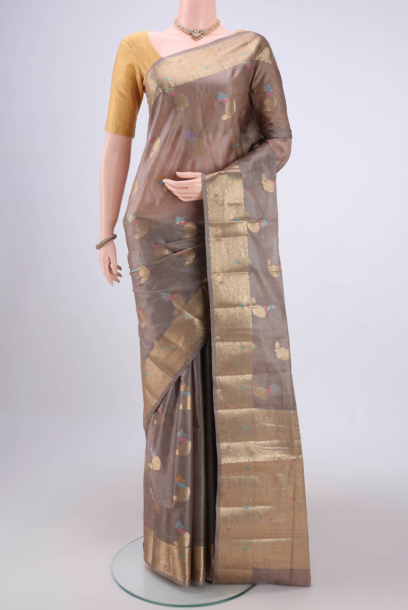 Dark Beige Banarasi Tussar Silk Saree with Zari And Thread Butta on the body and Zari And Thread Border.  displayed on a mannequin
