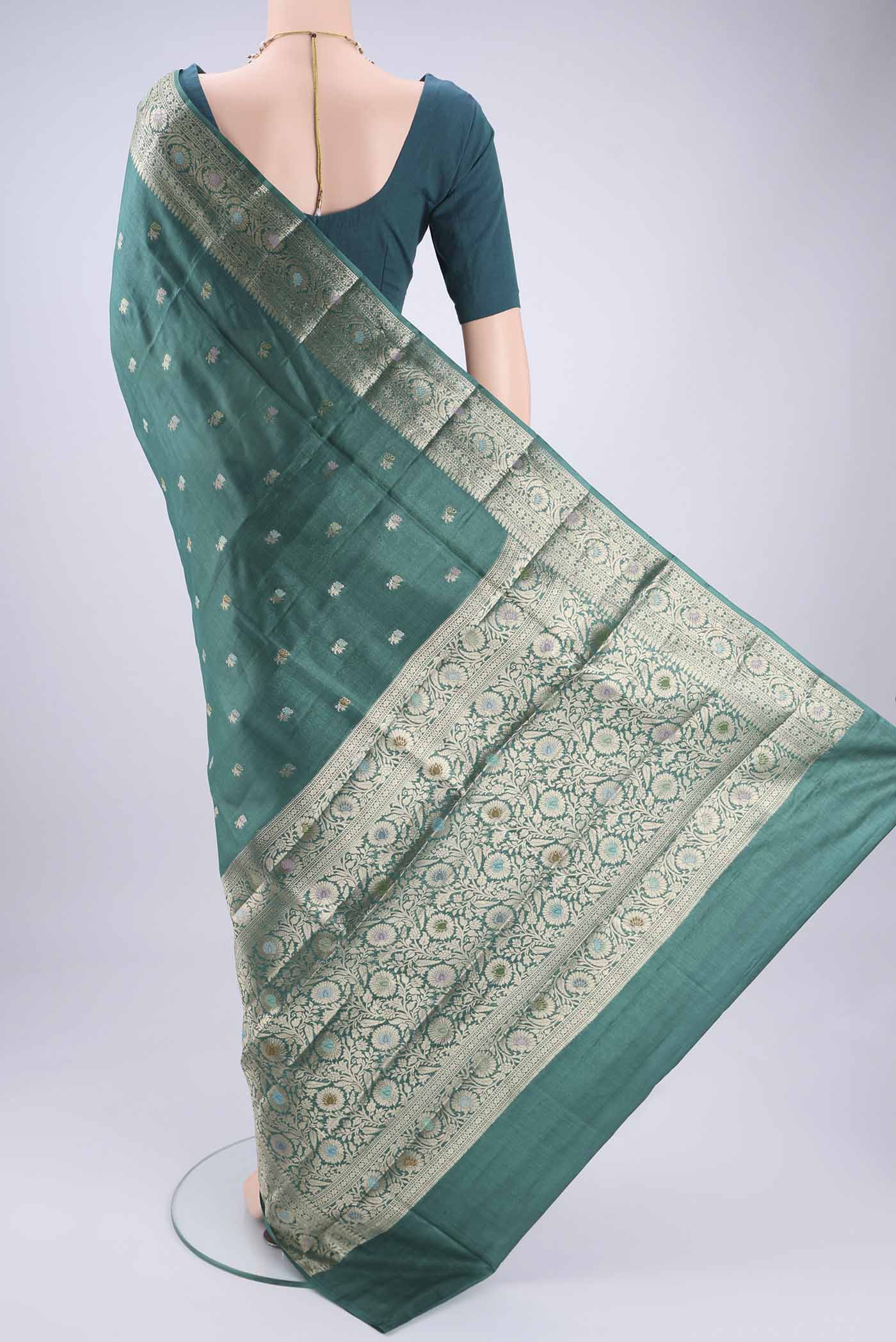 Flat view of Green Banarasi Tussar Silk Saree with Zari Butta on the body and Zari And Thread Border. 