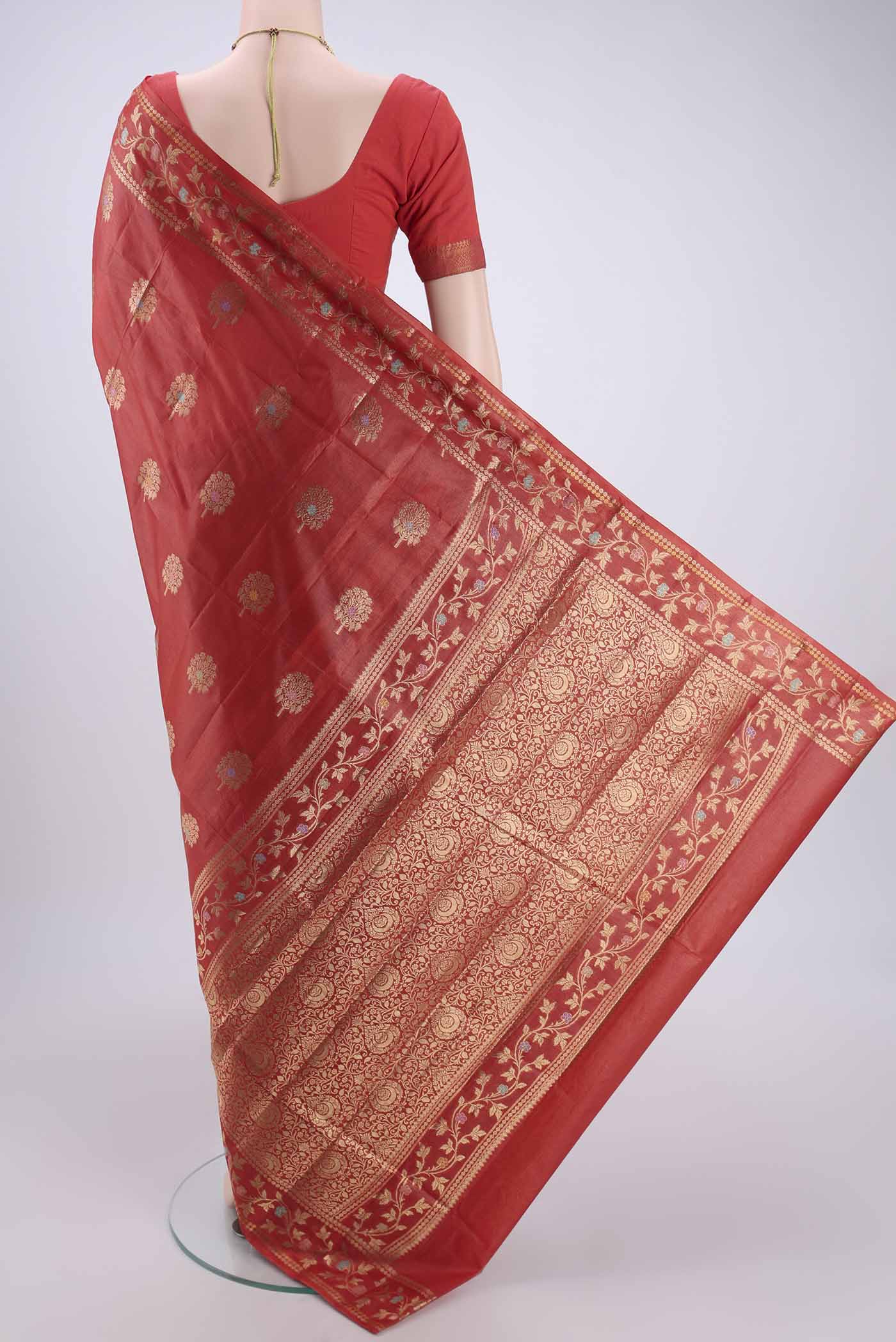 Flat view of Orange Banarasi Tussar Silk Saree with Zari And Thread Butta on the body and Zari And Thread Border. 