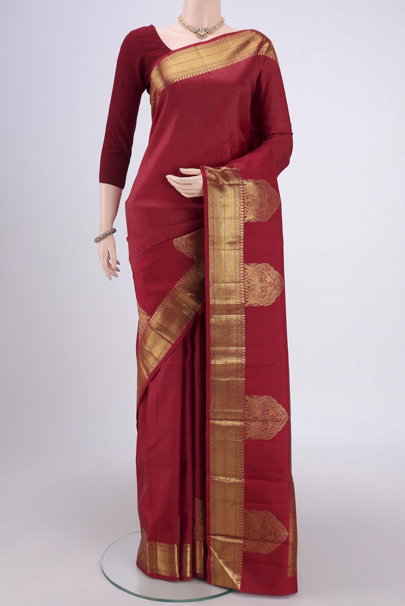 Maroon Dual Tone Kanchipuram Silk Saree with Checked design on the body and Attached Border.  displayed on a mannequin