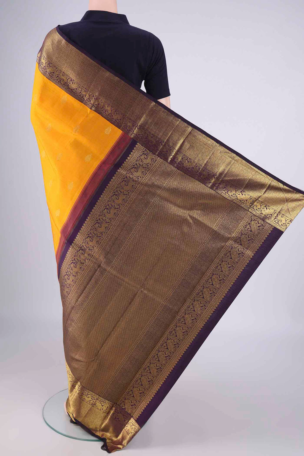 Flat view of Yellow Kanchipuram Silk Saree with Zari Butta on the body and Zari Border. 