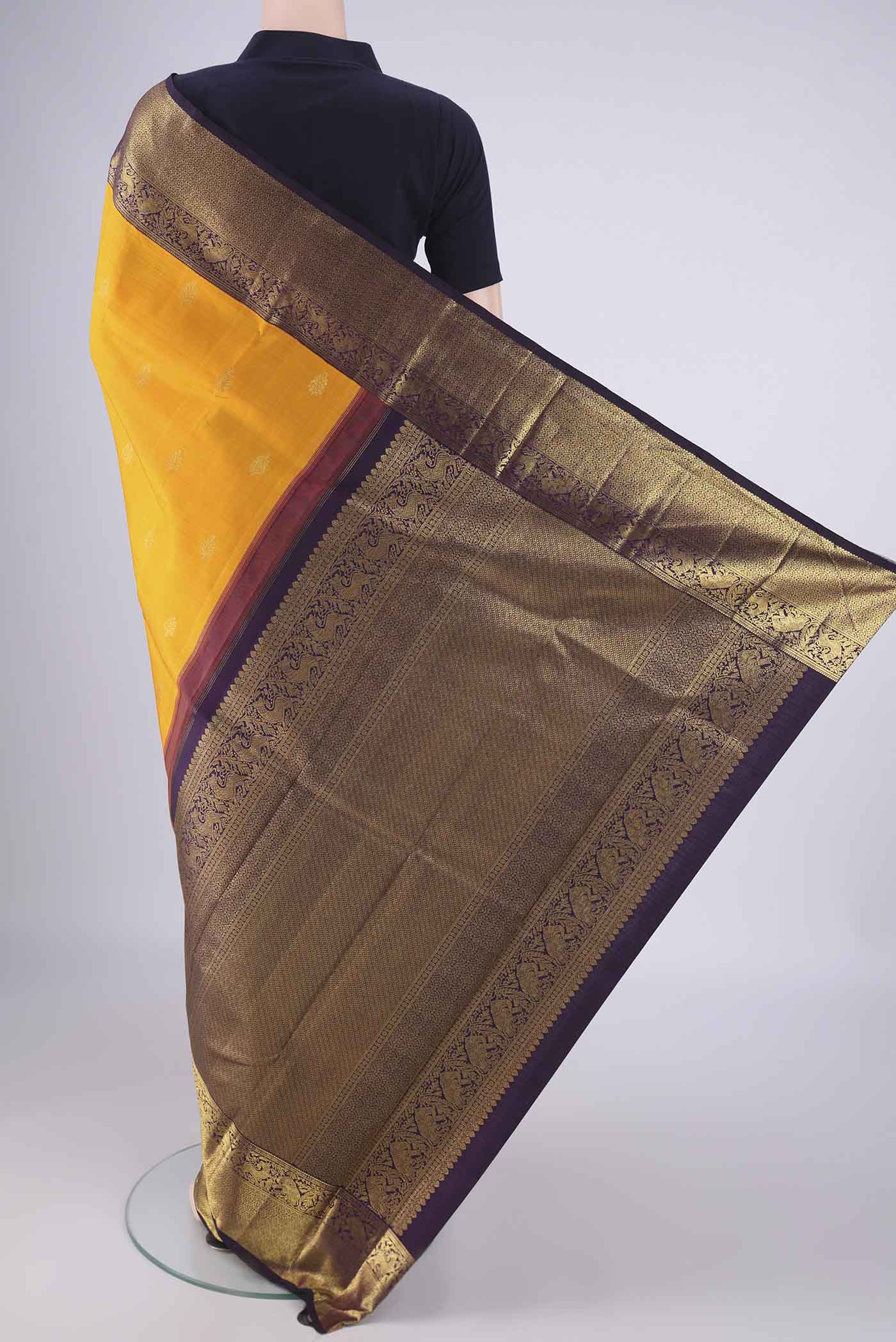 Flat view of Yellow Kanchipuram Silk Saree with Zari Butta on the body and Zari Border. 