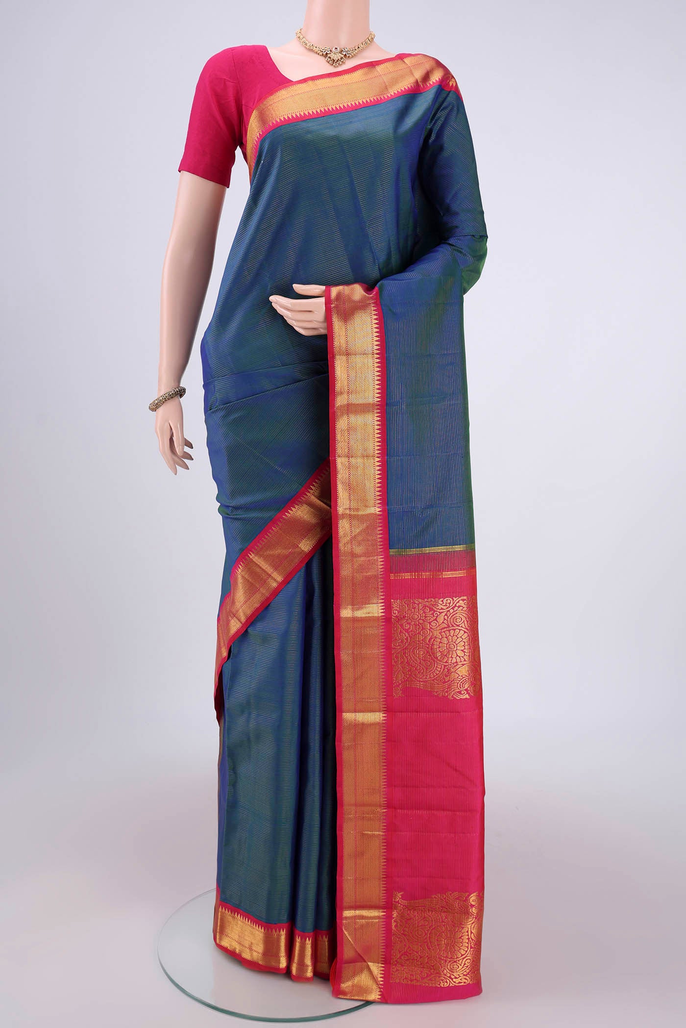 Pure Silk Pure Zari Peacock Blue Dual Tone Kanchipuram Saree with Stripes on the body and Temple Border.  displayed on a mannequin