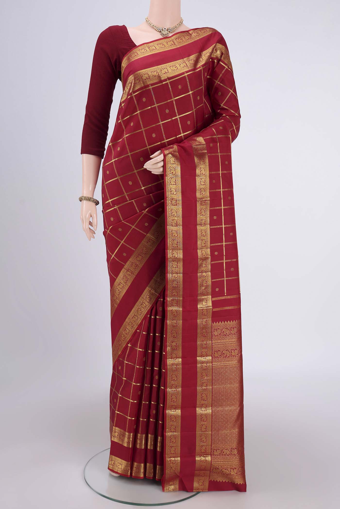 Pure Silk Pure Zari Maroon Kanchipuram Saree with Checked design on the body and Zari Border.  displayed on a mannequin
