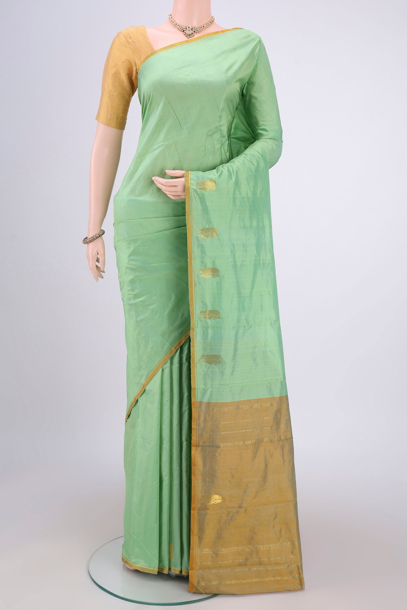 Mint Green Kanchipuram Silk Saree with Plain Body and Thread Border.  displayed on a mannequin