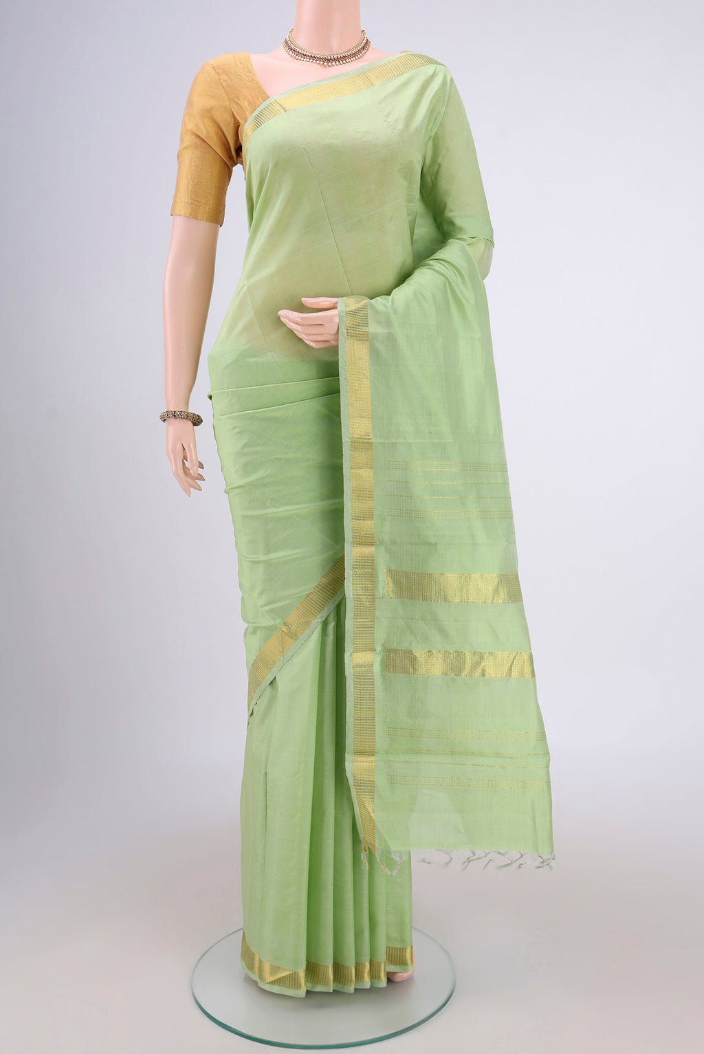 Light Green Kanchipuram Silk Saree with Plain Body and Zari Border.  displayed on a mannequin