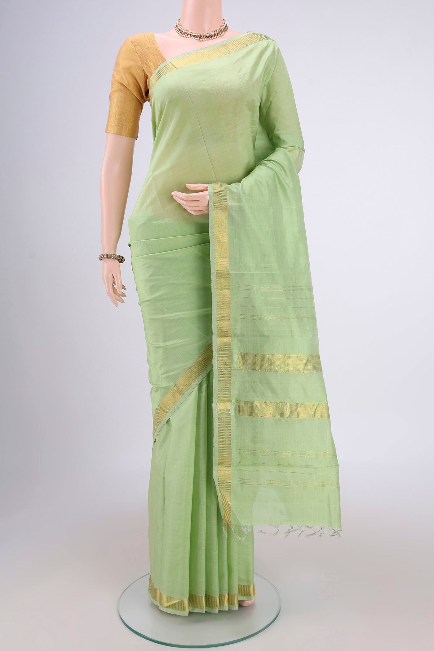Light Green Kanchipuram Silk Saree with Plain Body and Zari Border.  displayed on a mannequin