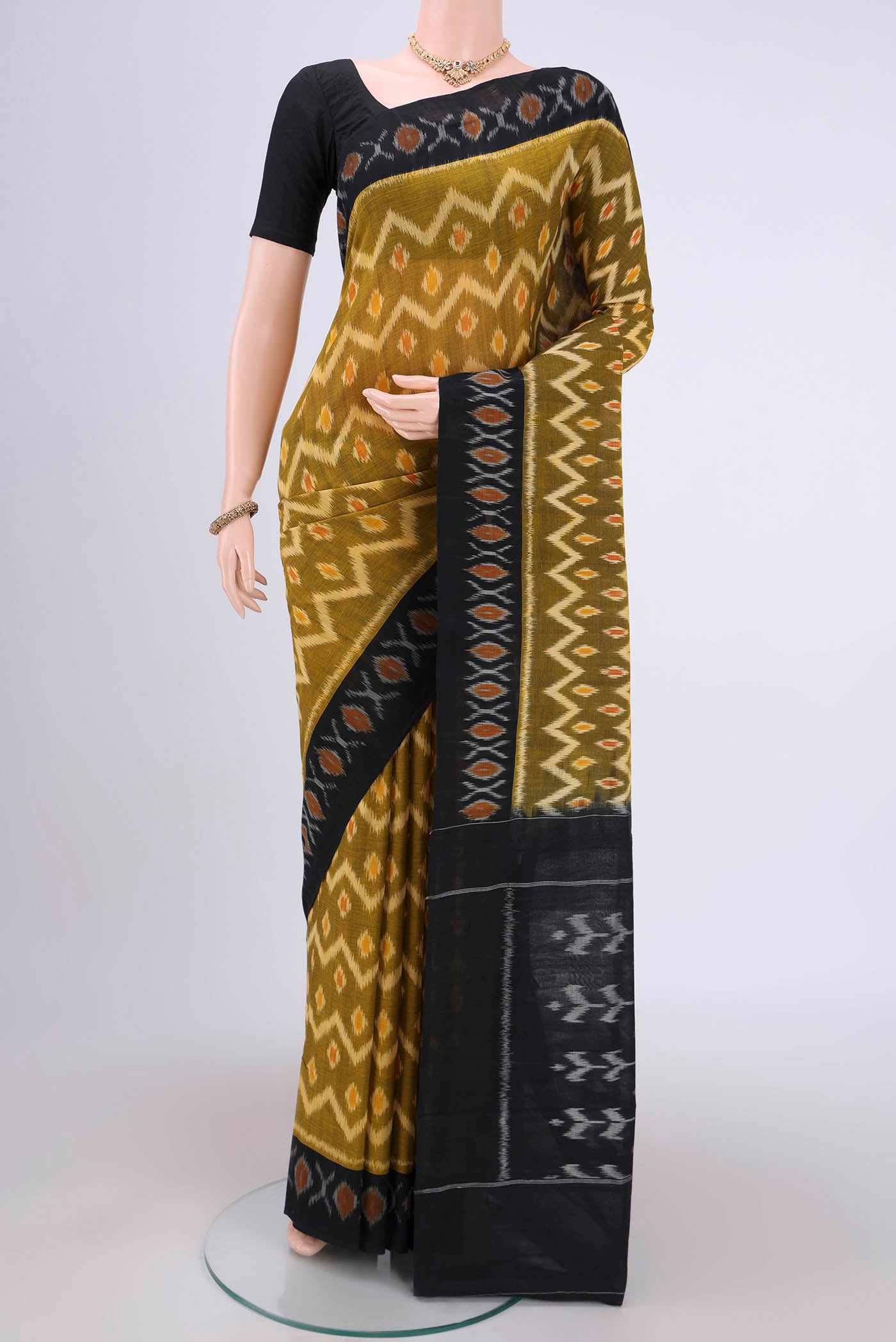 Mehandi Green Pochampally Cotton Saree with Ikat design on the body and Ikat Border.  displayed on a mannequin