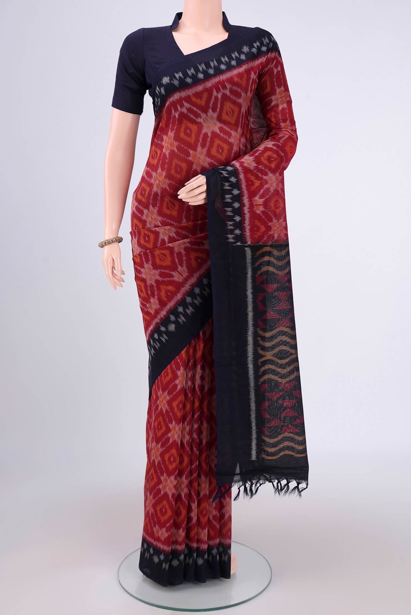 Maroon Pochampally Cotton Saree with Ikat design on the body and Ikat Border.  displayed on a mannequin