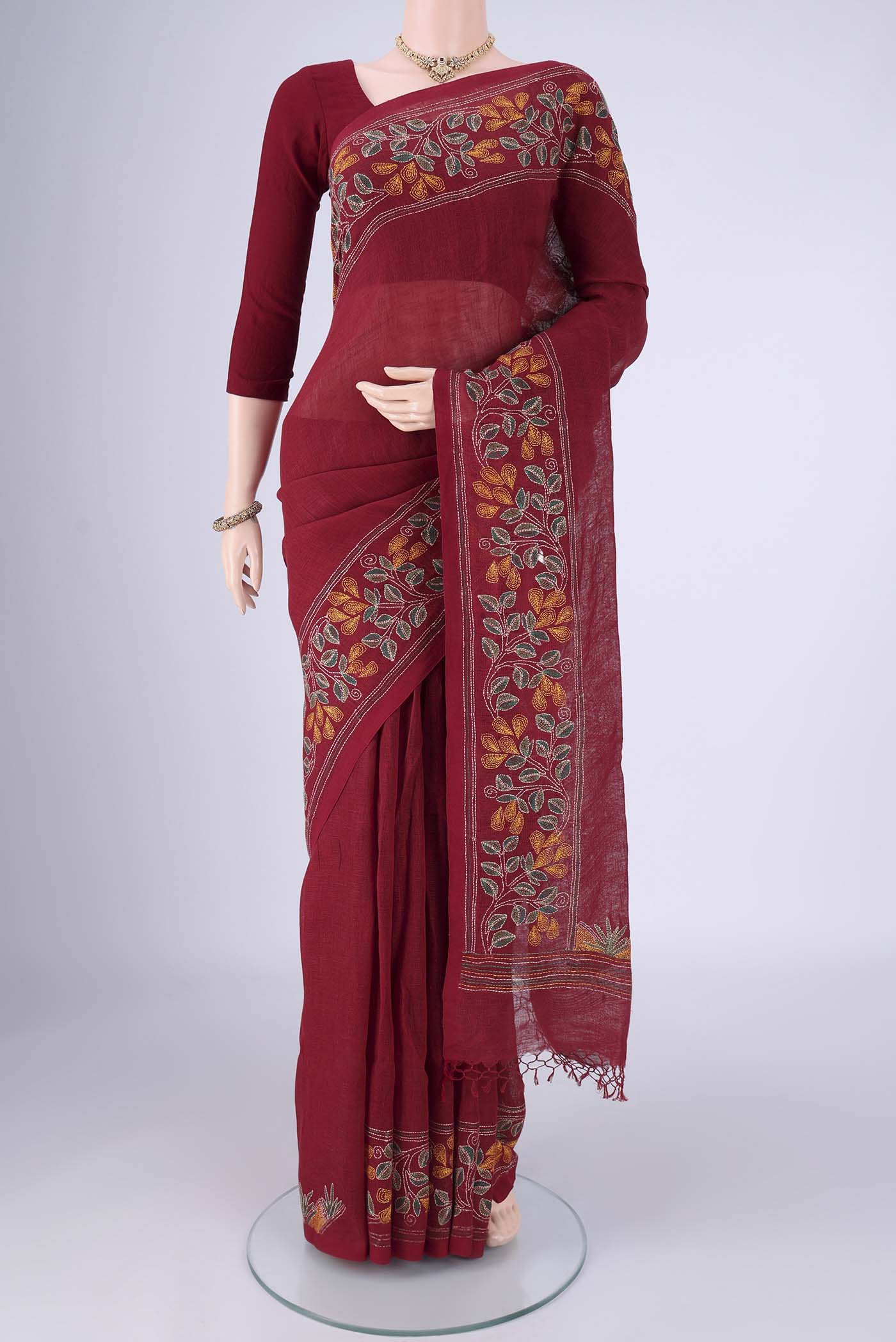 Maroon Linen Cotton Saree with Kantha Work on the body and Thread Border.  displayed on a mannequin