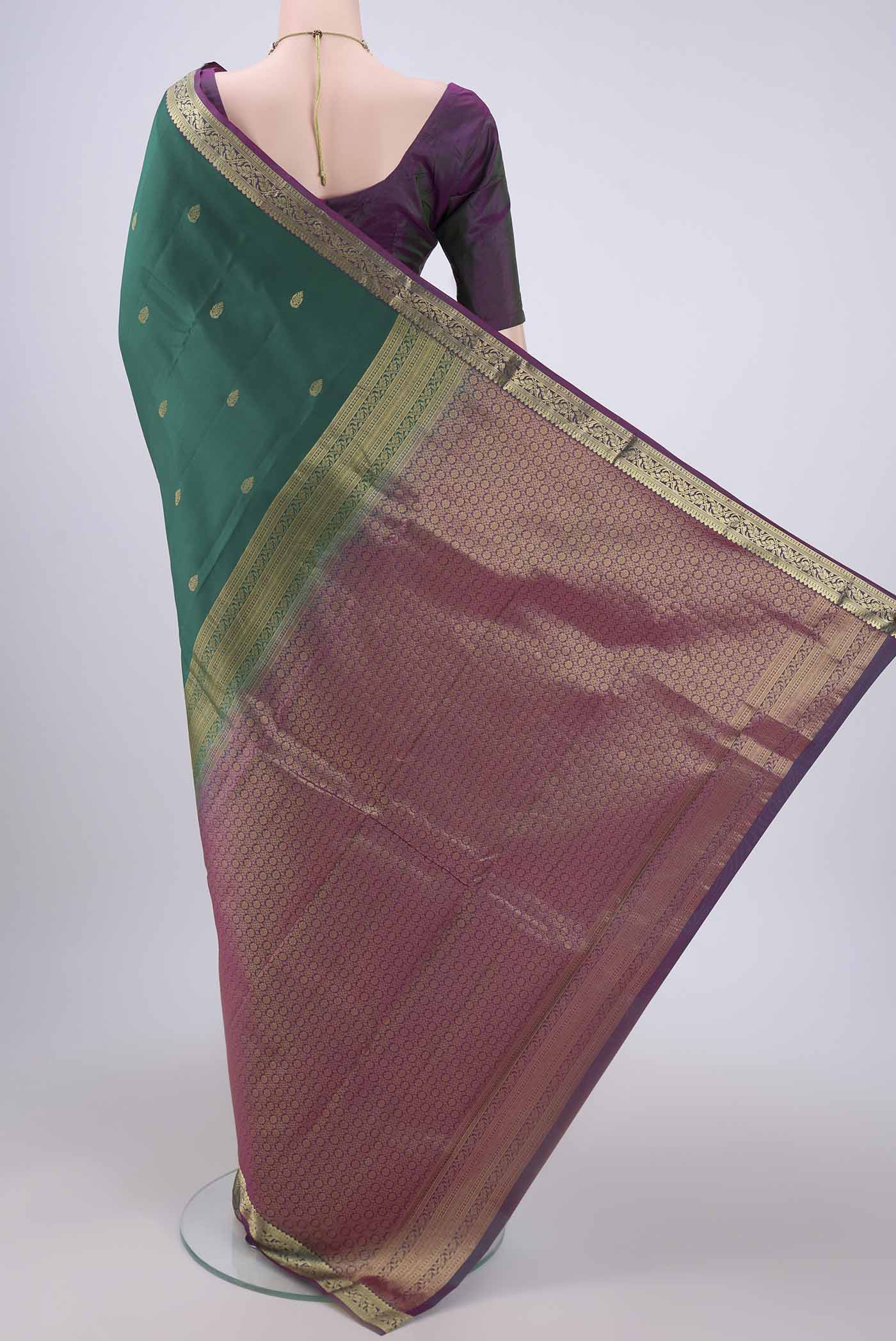 Flat view of Bottle Green Kanjivaram Silk Saree with Zari Butta on the body and Zari Border. 