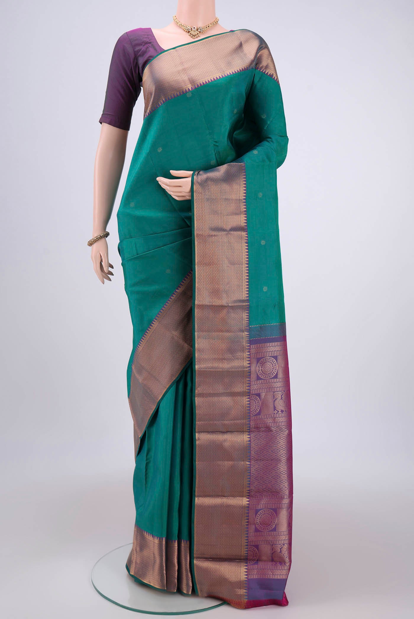 Green Kanchipuram Silk Saree with Zari Butta on the body and Zari Border.  displayed on a mannequin